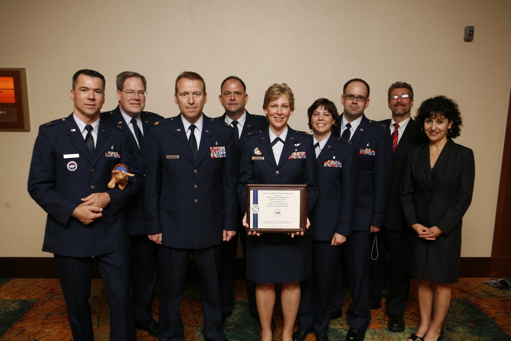 On hand to receive the award at the conference were, from left to right, Capt. Vic Holmes, Col. John Bullock, Maj. Mike Arnholtz, Lt. Col. John Chitwood, Maj. Melanie Ellis, Capt. Brandi Ritter and Capt. Cliff Otte. and retired Air Force Maj. John Notabartolo  Also picuted is AAPA official Linda Contreras, at the far right