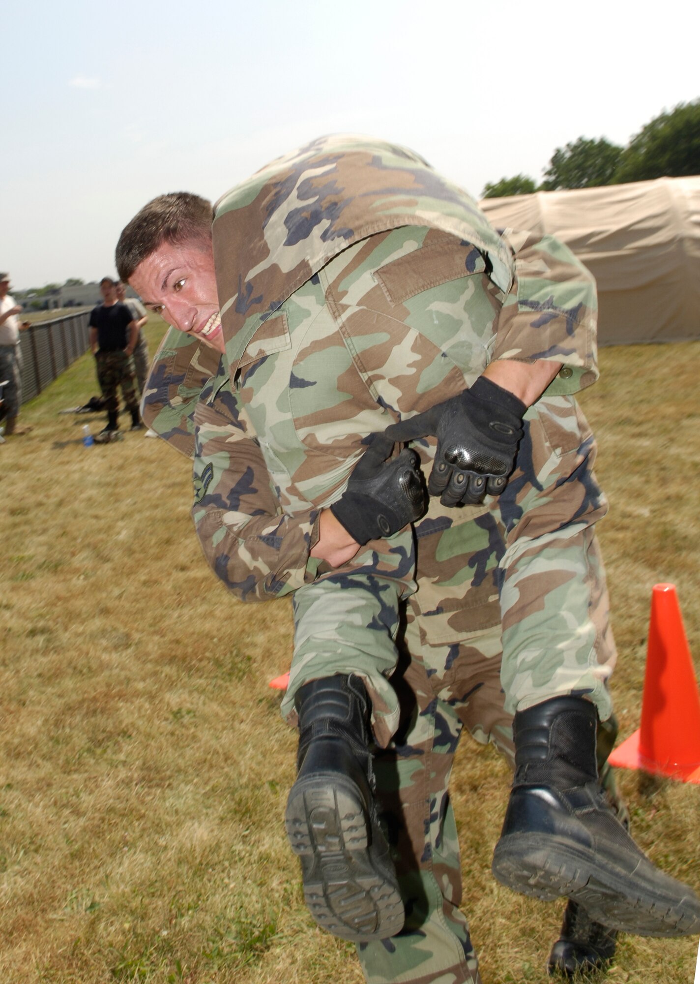 Airman Shawn McQueen carries teammate Airman Timothy Dent, both from the 818th Global Mobility Readiness Squadron, during the buddy-carry segment of the obstacle course as part of the 621st Contingency Response Wing Combat Field Day June 27 here. The field day consisted of numerous events, including the ruck-sack relay, tent building and an obstacle course. (U.S. Air Force photo/Kenn Mann)