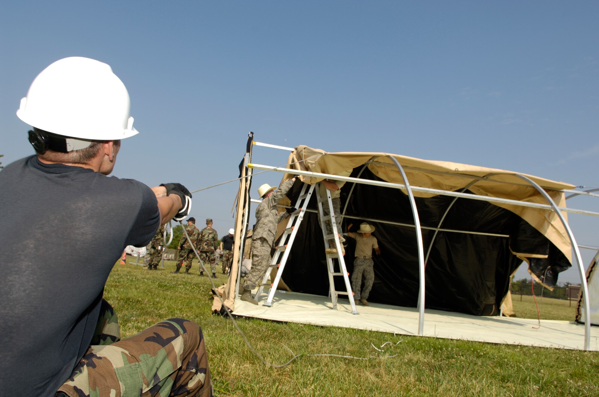 A member of the 819th Global Support Squadron pulls on a rope to put on the cover of a tent during the Alaskan tent building event as part of the 621st Contingency Response Wing Combat Field Day June 27 here. The field day consisted of numerous events, including the ruck-sack relay, tent building and an obstacle course. (U.S. Air Force photo/Kenn Mann)