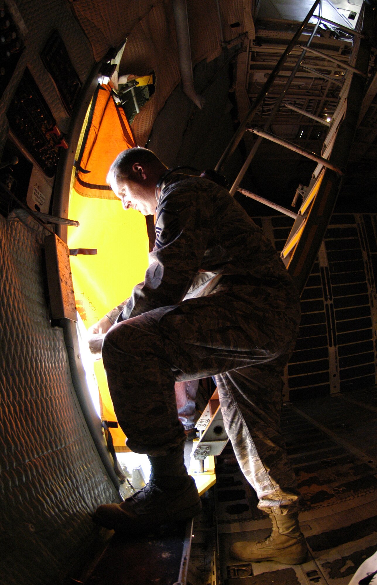 DOVER AIR FORCE BASE, Del. -- Master Sergeant Wayne Baker, 436th Aircraft Maintenance Squadron, attaches a tarp to the door of a C-5 Galaxy before it is treated for Japanese beetles June 30. Once tarp is up in cannot be removed until the flight door is closed immediately before take off. All military and civilian aircraft leaving DAFB and traveling to one of nine quarantined states west of the Rocky Mountains must be debugged by entomologists before it can fly. The measures, enforce by the U.S. Department of Agriculture, stop the artificial spread of the Japanese beetle which could devastate crops in California and other western states. (U.S. Air Force photo/Senior Airman James Bolinger)