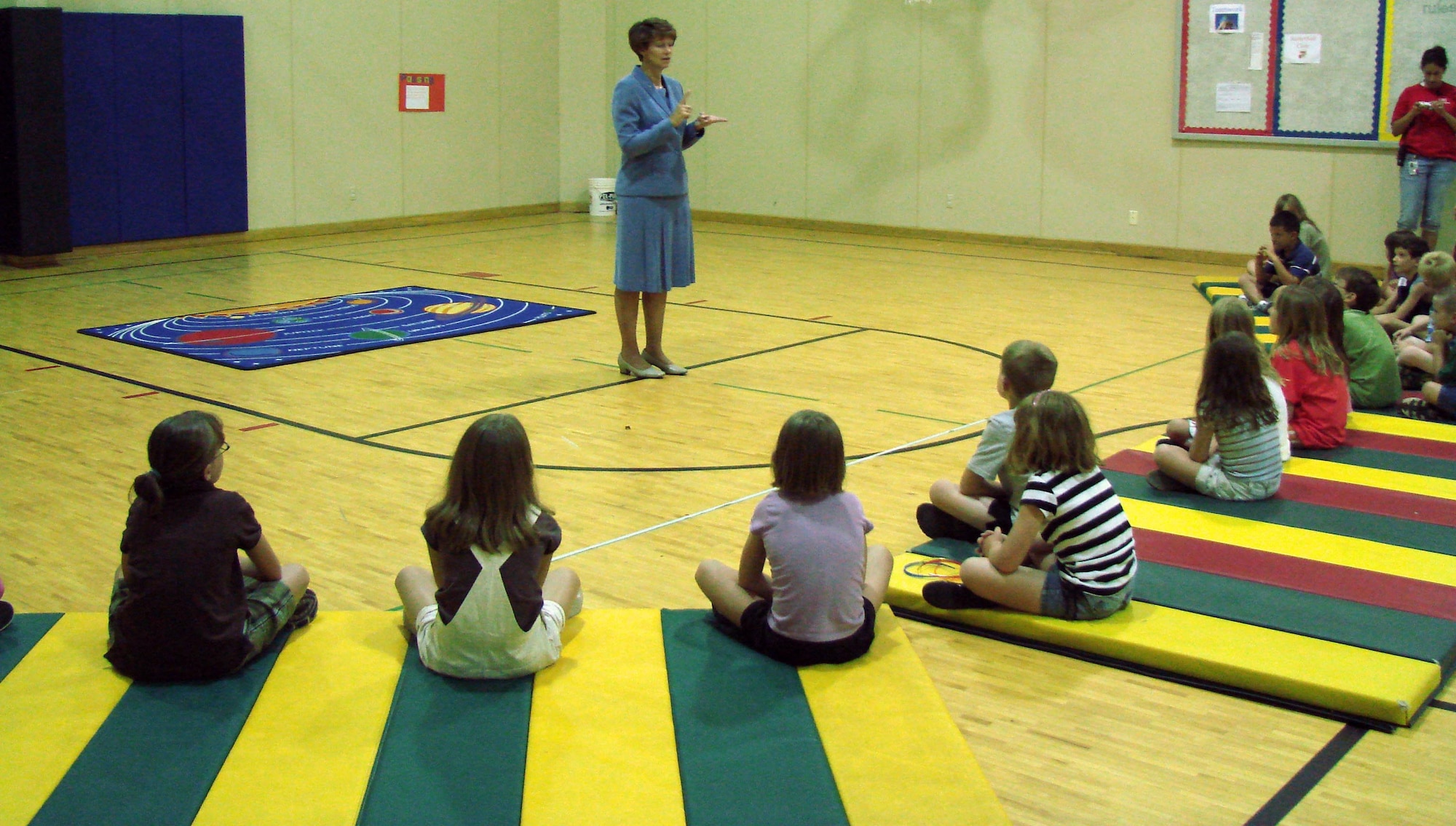 Retired Air Force Col. Eileen Collins, a former astronaut from NASA and a 1979 first assignment instructor pilot at Vance AFB, Okla. visits the Youth Center and discusses with the kids about her space shuttle flights using the solar system rug directly behind her.. (U.S. Air Force photo by Joe Wiles)