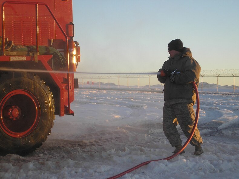 BAGRAM AIR FIELD, Afghanistan - Senior Airman Charles Nichols, Jr., 455th Expeditionary Logistics Readiness Squadron special purpose vehicle maintenance-fire truck mechanic, uses a high-power water hose to clean the tires of a fire truck at Bagram Air Field, Afghanistan, May. 31. Airman Nichols is deployed from the 436th LRS, Dover Air Force Base, Del. (Courtesy photo)
