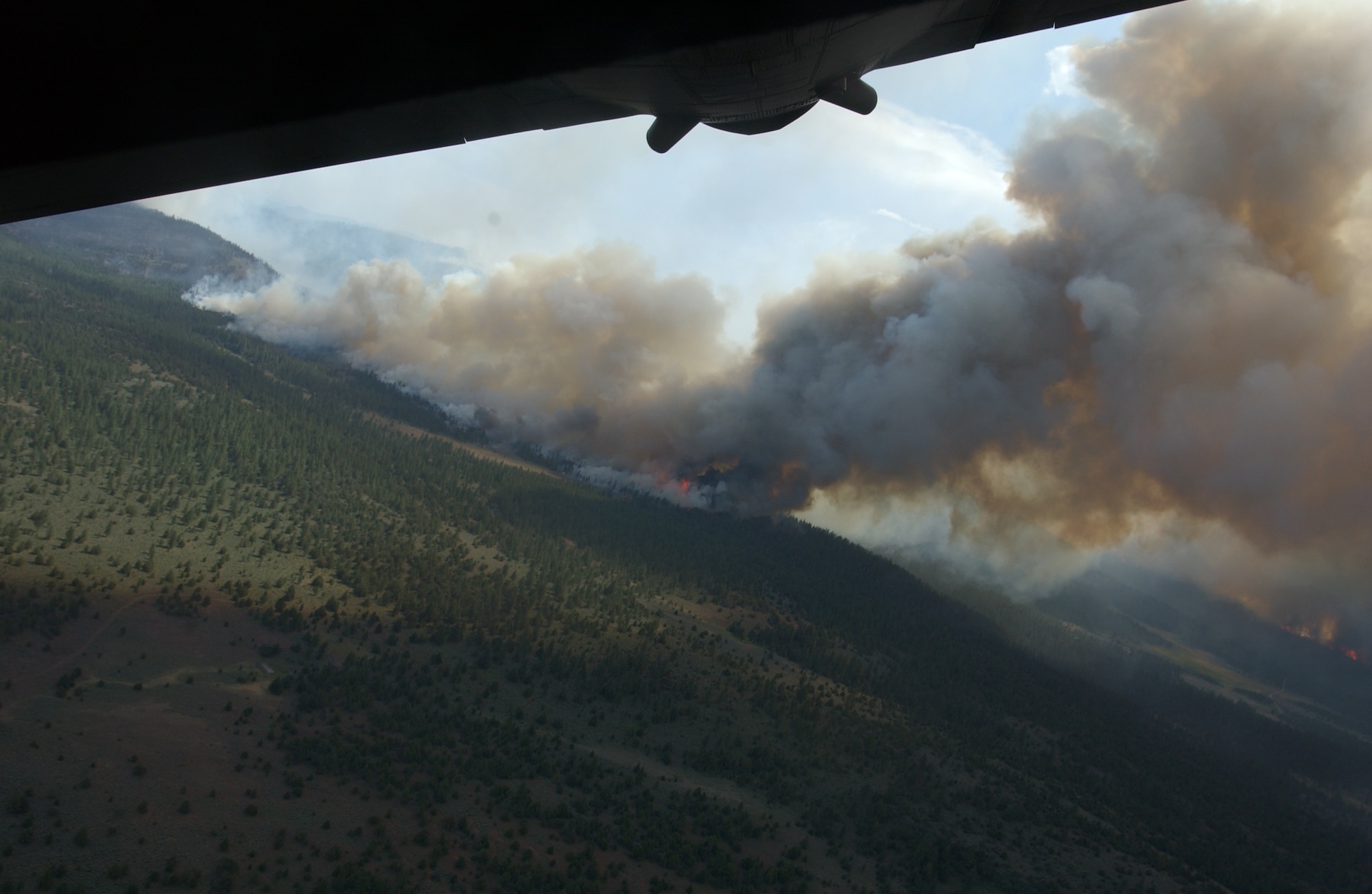 A C-130 Hercules assigned to the 302nd Air Expeditionary Group banks for home June 28 after dropping a load of fire retardant on the Corral fire located more than 180 miles north of Sacramento, Calif. As of 6:30 p.m. June 28, aircrews had seven missions against the fire, dropping 21,000 gallons of fire retardant. The 302nd AEG is made up of two Air National Guard units, including the 153rd AW, from Cheyenne, Wyo., and the 145th AW, Charlotte, N.C. One Air Force Reserve unit, the 302nd AW from Peterson Air Force Base, Colo., is the only Air Force Reserve unit in the 302nd AEG. (U.S. Air Force photo/Senior Master Sgt. Dennis Martin)