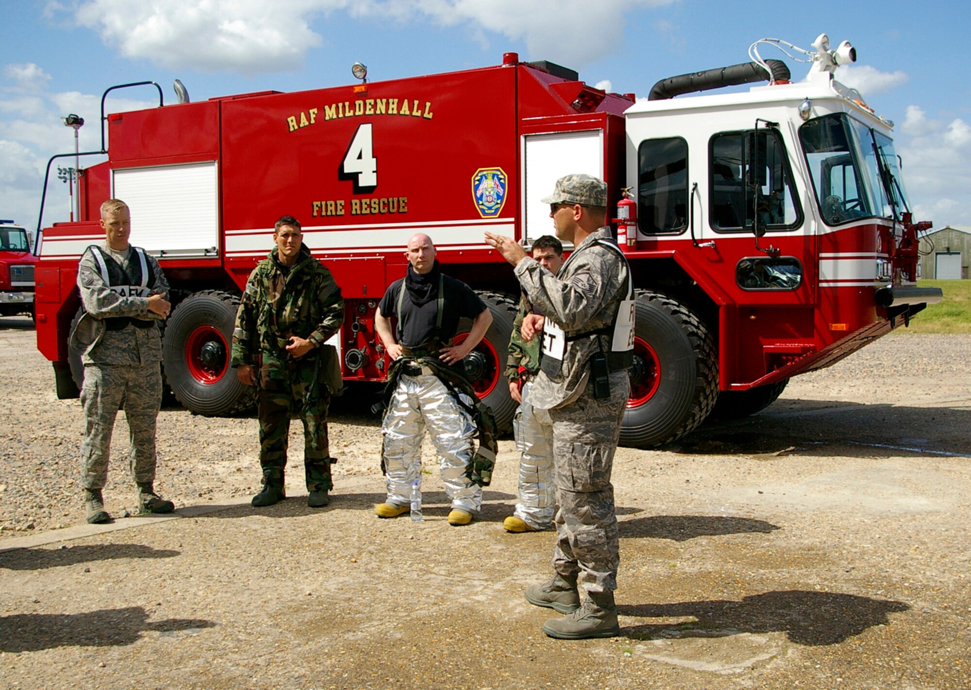 Master Sgt. Dennis Schipper (far right), 100th Civil Engineer Squadron Fire Department, gives a quick debrief to firefighters and Chief Master Sgt. Michael Warner, 100th Air Refueling Wing command chief, after the exercise response June 25. RAF Mildenhall conducted a base-wide Phase II exercise June 24 to 26 to better prepare Airmen for deployments and wartime environments and to train for the upcoming operational readiness inspection in 2009. (U.S. Air Force photo by Karen Abeyasekere)
