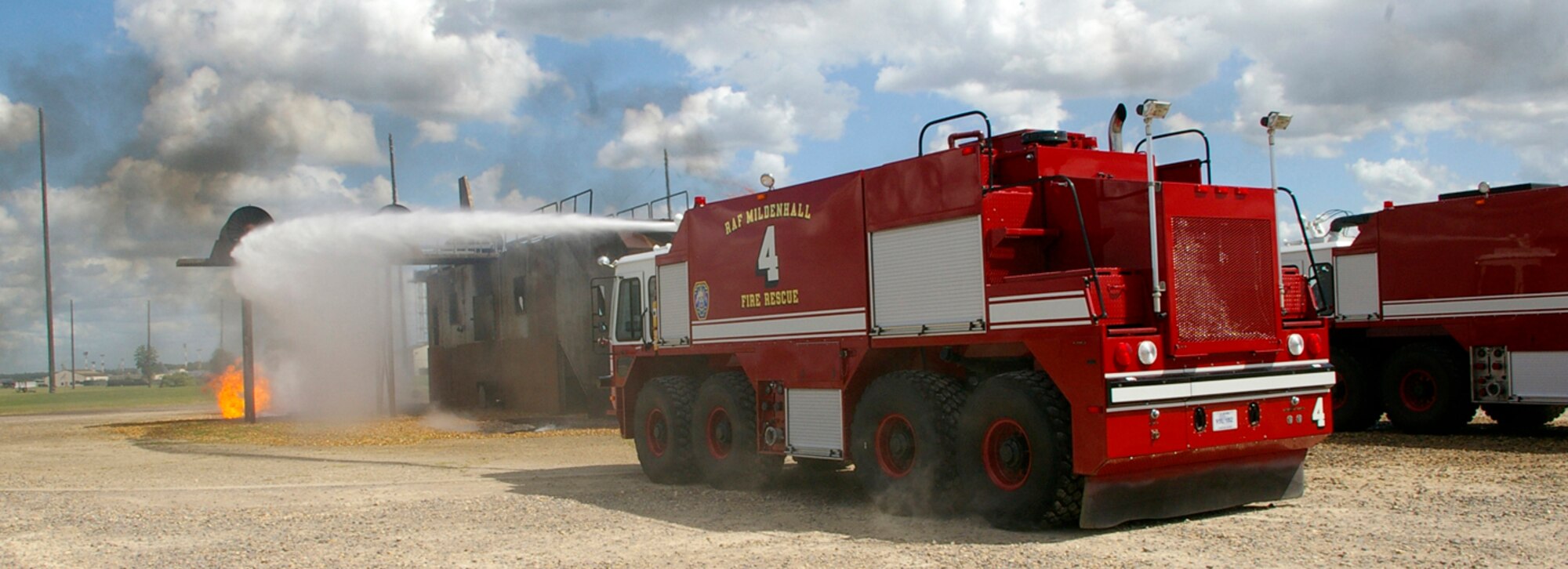 The second fire truck at the live fire training pit sprays water onto the far side of the mock aircraft during a response scenario as part of the exercise June 25. RAF Mildenhall conducted a base-wide Phase II exercise June 24 to 26 to better prepare Airmen for deployments and wartime environments and to train for the upcoming operational readiness inspection in 2009. (U.S. Air Force photo by Karen Abeyasekere)
