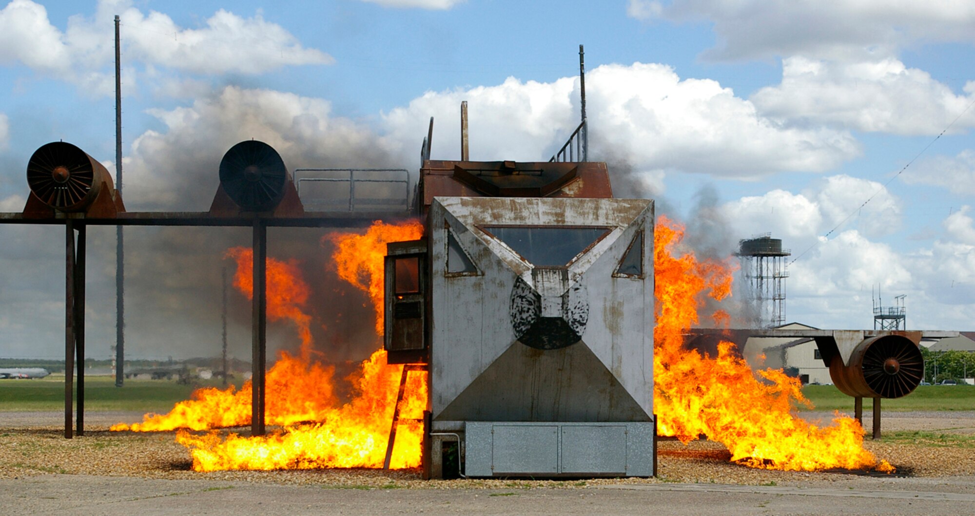 The mock aircraft at the live fire training pit is set alight in preparation of a response scenario during the exercise June 25. RAF Mildenhall conducted a base-wide Phase II exercise June 24 to 26 to better prepare Airmen for deployments and wartime environments and to train for the upcoming operational readiness inspection in 2009. (U.S. Air Force photo by Karen Abeyasekere)
