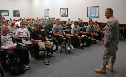 Chief Master Sgt. Stephen Page, 12th Flying Training Wing command chief, talks with Airmen, Soldiers and Marines June 27 in the 559th Flying Training Squadron briefiing room. Thirteen wounded warriors who are currently receiving care at the Center for the Intrepid at Brooke Army Medical Center in San Antonio, joined base leaders for a VIP tour of Randolph AFB to learn about the 12th Flying Training Wing mission. (U.S. Air Force photo by Rich McFadden)