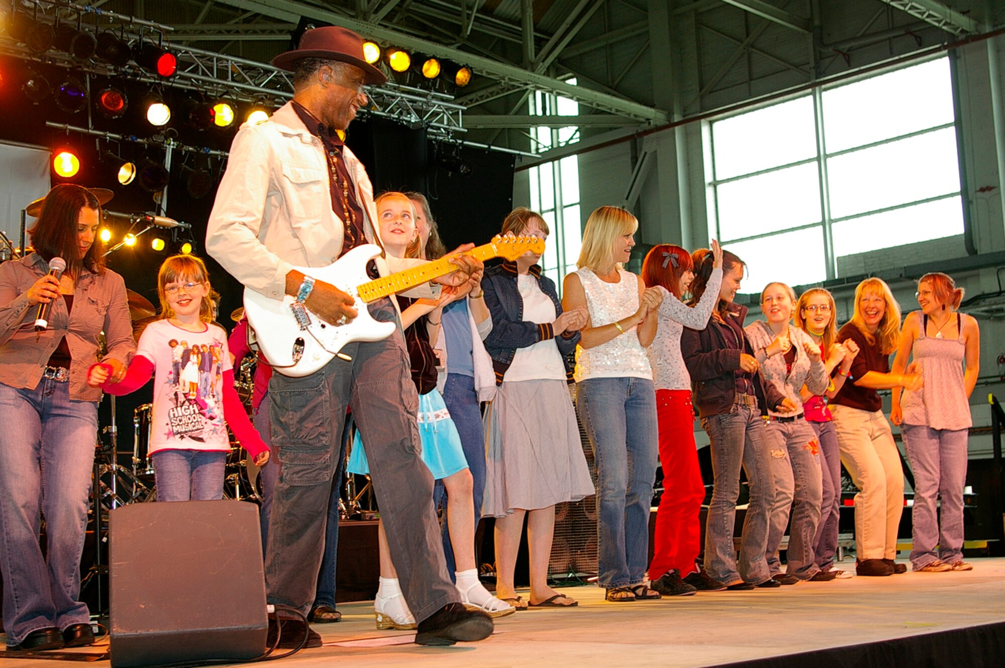 Gina Gonzalez, left, vocalist with the Lt. Dan Band, and Kimo Williams, guitar, dance with some female members of the audience during Patti Labelle's "Lady Marmalade" at the Lt. Dan Band concert June 29 at RAF Mildenhall. The band was here as part of a United Services Organization tour, playing to servicemembers around the world to show their support for them. Approximately 650 people watched the concert as the Lt. Dan Band interacted with the crowd and kept everyone entertained for the two-hour show. (U.S. Air Force photo by Karen Abeyasekere)