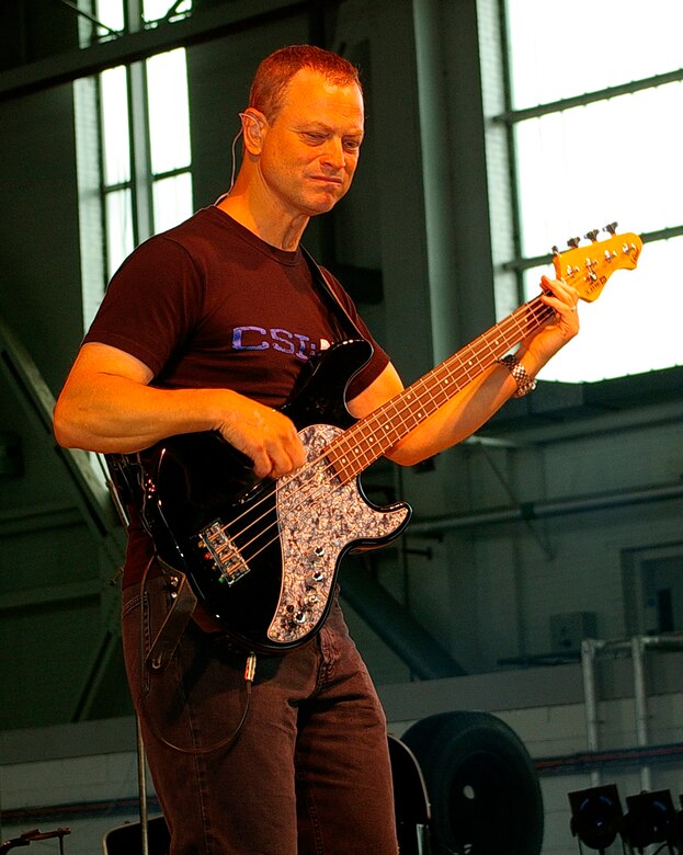 Actor Gary Sinise, bass guitarist and founder of the Lt. Dan Band, gets into the music as he and the rest of the band entertain Airmen and their families at RAF Mildenhall June 29. The band was here as part of a United Services Organization tour, playing to servicemembers around the world to show their support for them. Approximately 650 people watched the concert as the Lt. Dan Band interacted with the crowd and kept everyone entertained for the two-hour show. (U.S. Air Force photo by Karen Abeyasekere)