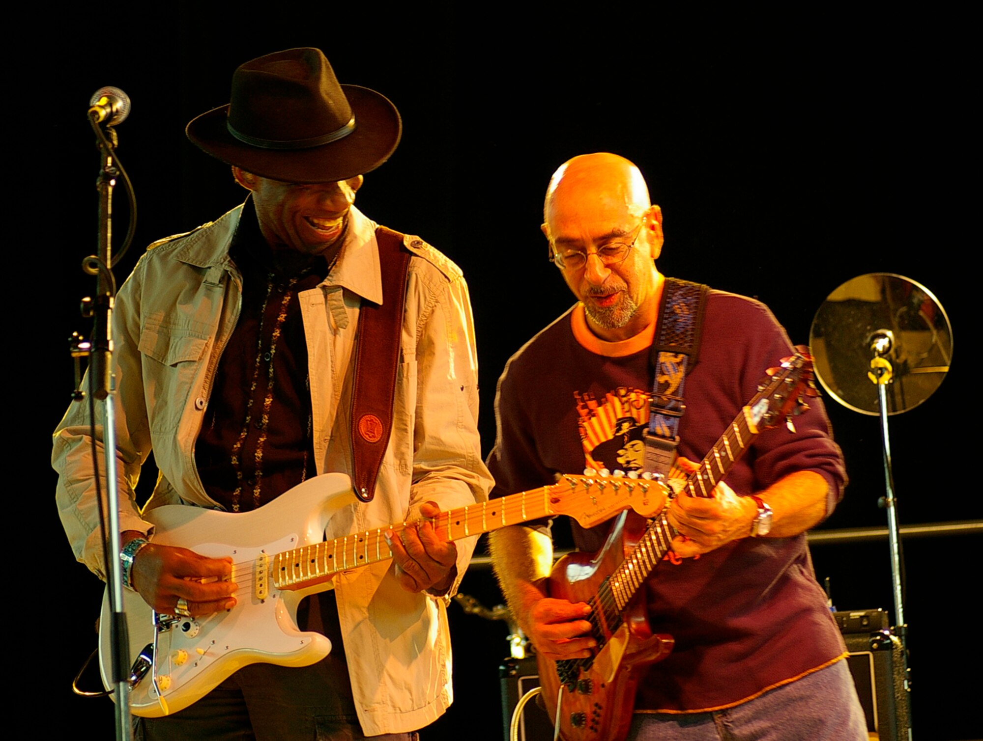 Kimo Williams (left) and Ernie Denov, simultaneously play guitars during a Lt. Dan Band concert June 29 at RAF Mildenhall. The band was here as part of a United Services Organization tour, playing to servicemembers around the world to show their support for them. Approximately 650 people watched the concert as the Lt. Dan Band interacted with the crowd and kept everyone entertained for the two-hour show. (U.S. Air Force photo by Karen Abeyasekere)