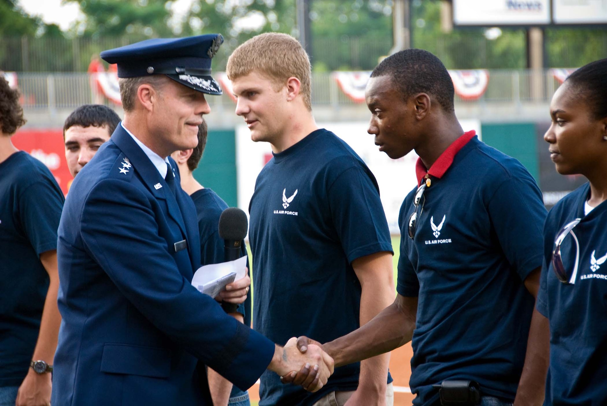 Lt. Gen. Allen G. Peck, Air University commander, congratulates Monteco Perry June 28, on taking the oath of enlistment. Mr. Perry is in the Delayed Entry Program and is qualified and waiting for a basic training slot. General Peck administered the oath to 21 future Airmen during the Montgomery Biscuits Military Appreciation Night. (U.S. Air Force photo)