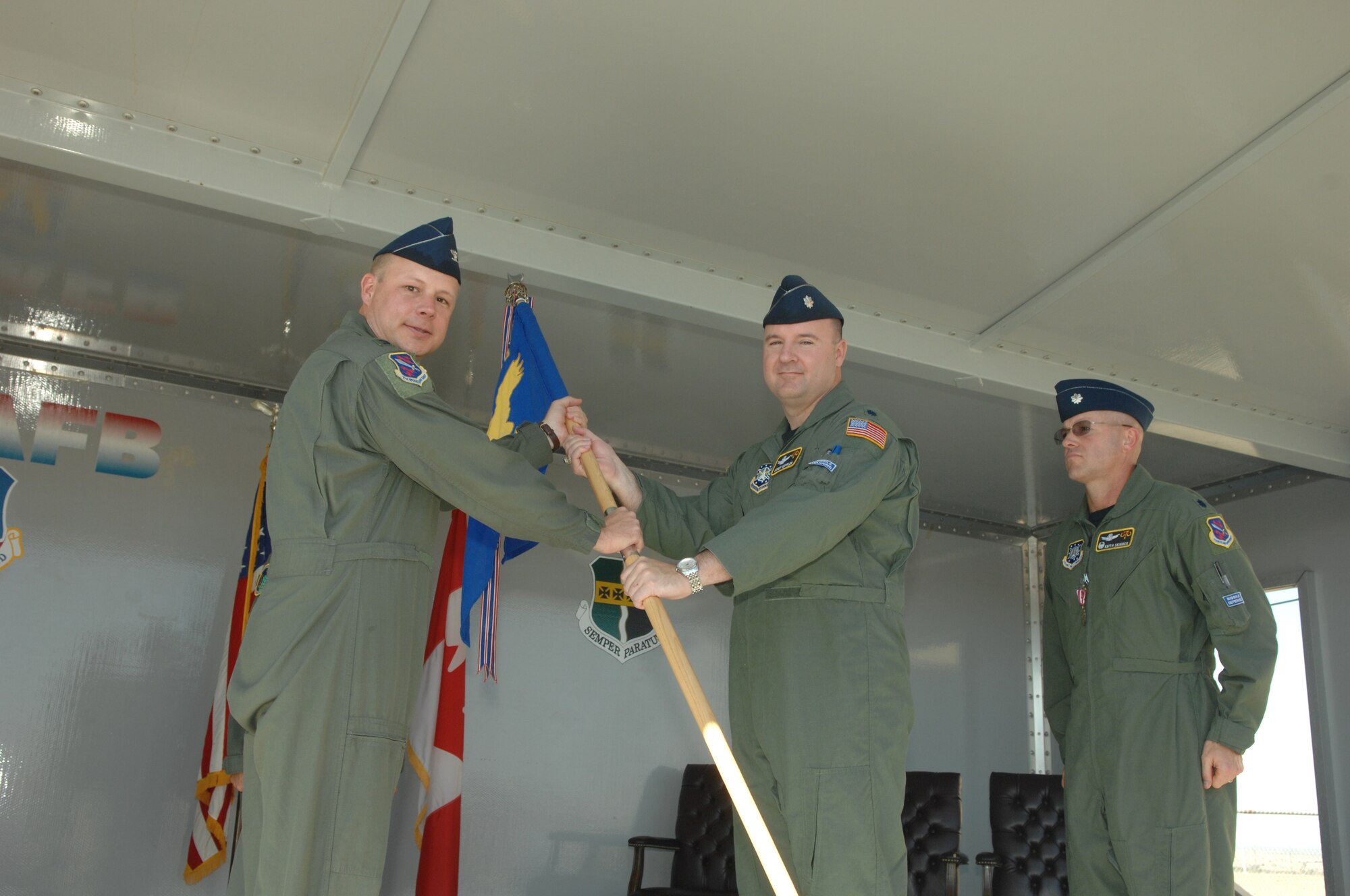 Col. Chris Crawford,21st Operaions Group commander, hands the guidon of command to Lt. Col. Corey Keppler, the new 7th Space Warning Squadron commander, as Lt. Col. Keith Skinner, the outgoing commander, looks on.  Colonel Keppler is coming to the 7th SWS from his previous job as the Air Force Space Command deputy director of staff. Colonel Skinner is headed to the 460th Space Wing at Buckley Colo.