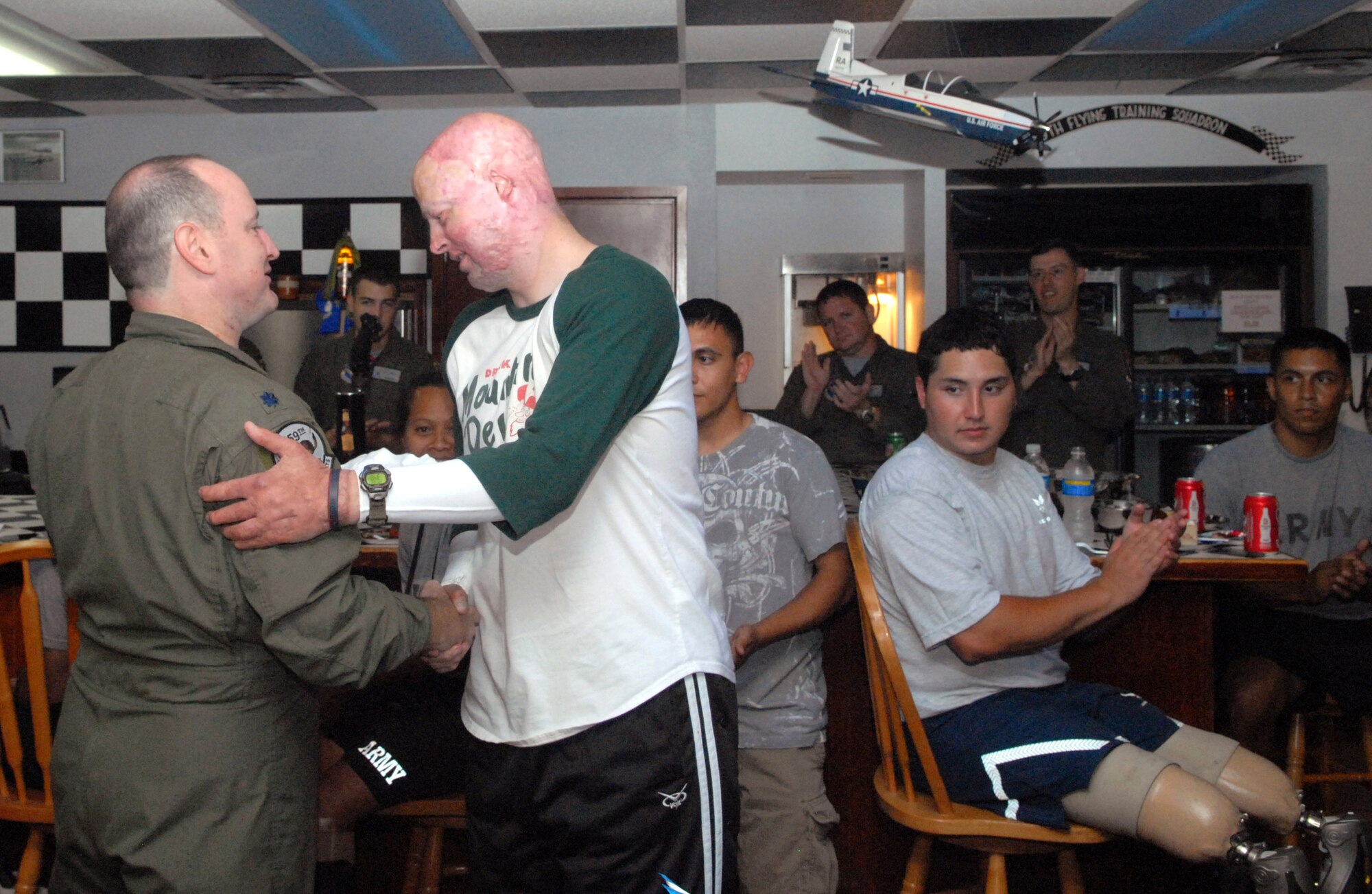 Marine Capt. Ryan Voltin thanks Lt. Col. Jimmy Donohue for hosting a tour of the 559th Flying Training Squadron during a June 27 trip to Randolph Air Force Base, Texas. Captain Voltin, a wounded war veteran, and 12 other wounded warfighters recovering from serious injuries toured the base and flew a simulator at the 559th Flying Training Squadron. The wounded warriors are currently receiving care at the Center for the Intrepid at Brooke Army Medical Center in San Antonio. Colonel Donohue is the 559th FTS commander. (U.S. Air Force photo/Rich McFadden) 
