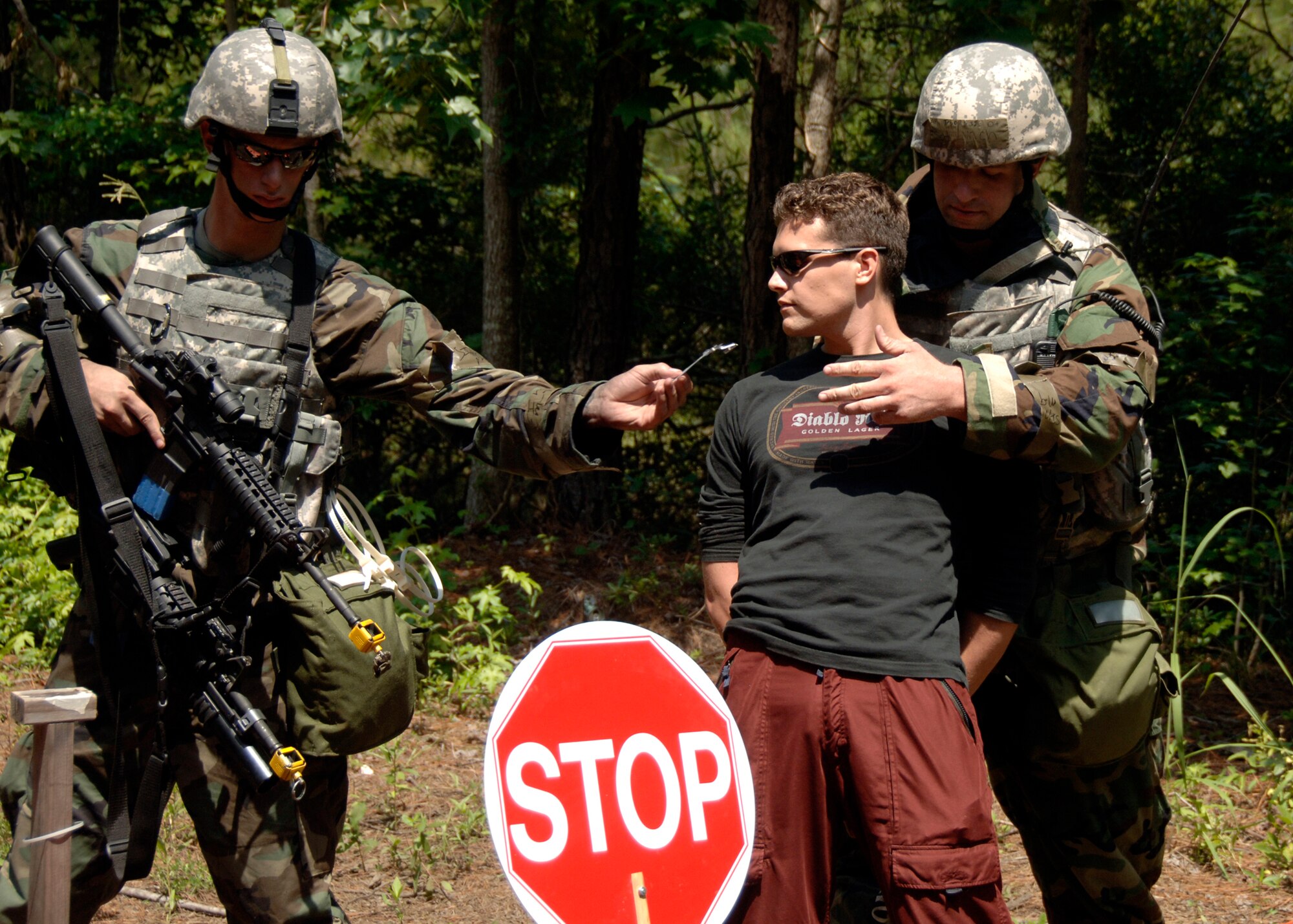 Staff Sgt. James Lynch hands Airman 1st Class Ryan Dodson an unidentified individual's fake identification after trying to gain unauthorized access to the base during the mobility exercise June 24 on Charleston AFB. Airmen from across the base are participating in a mobility exercise in preparation for the Headquarters Air Mobility Command operational readiness inspection in August. Sergeant Lynch is an expeditionary combat skills trainer and Airman Dodson is an installation entry controller for the 437th Security Forces Squadron. (U.S. Air Force photo/Airman 1st Class Timothy Taylor)