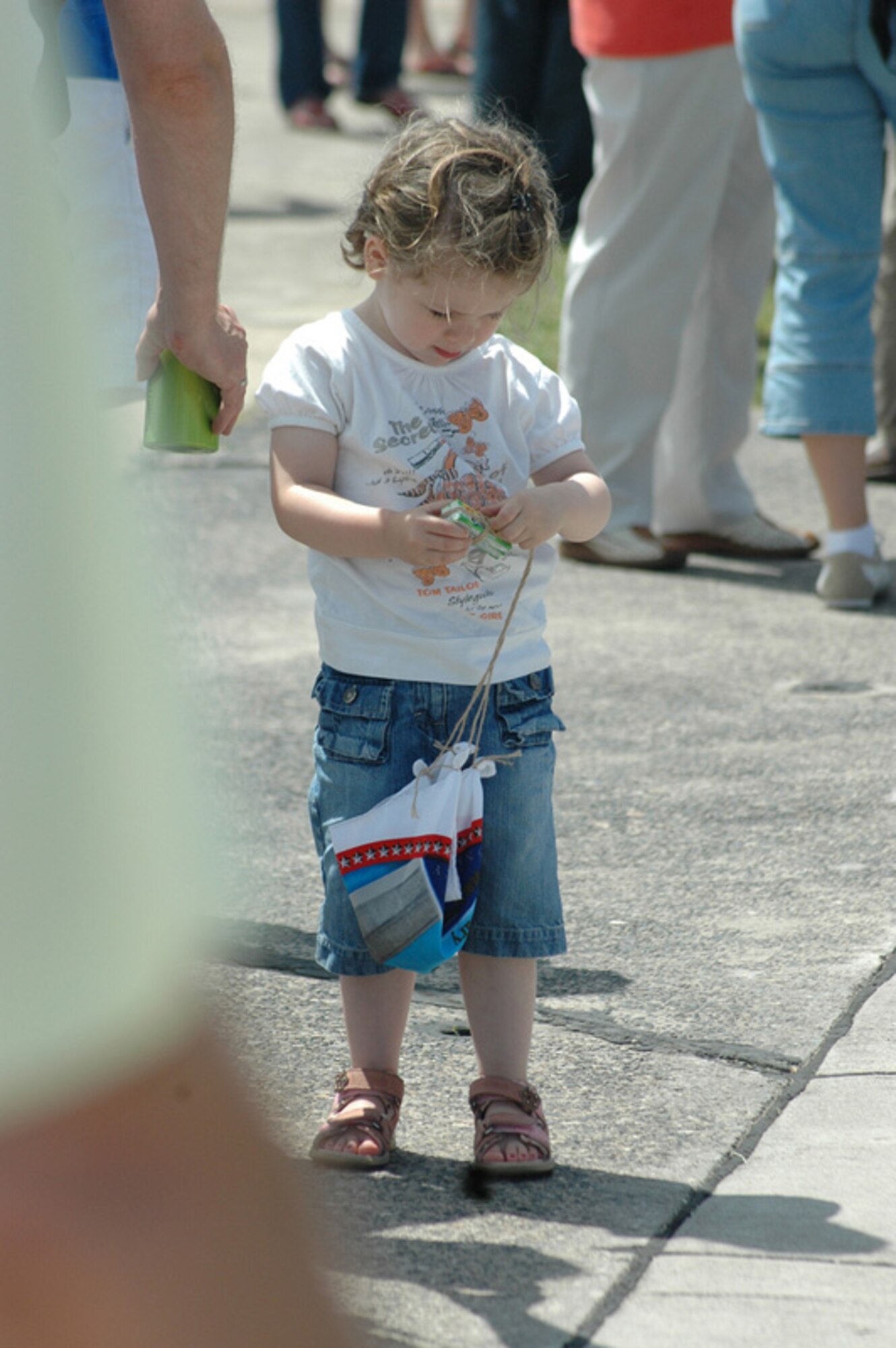 A child opens up a pack of gum that was dropped from a helicopter by retired Col. Gail Halvorsen, the legendary Candy Bomber, during celebrations held June 29, 2008, at Wiesbaden Army Airfield, Germany, marking the 60th anniversary of the humanitarian mission. (Photo by Kelli Bland)