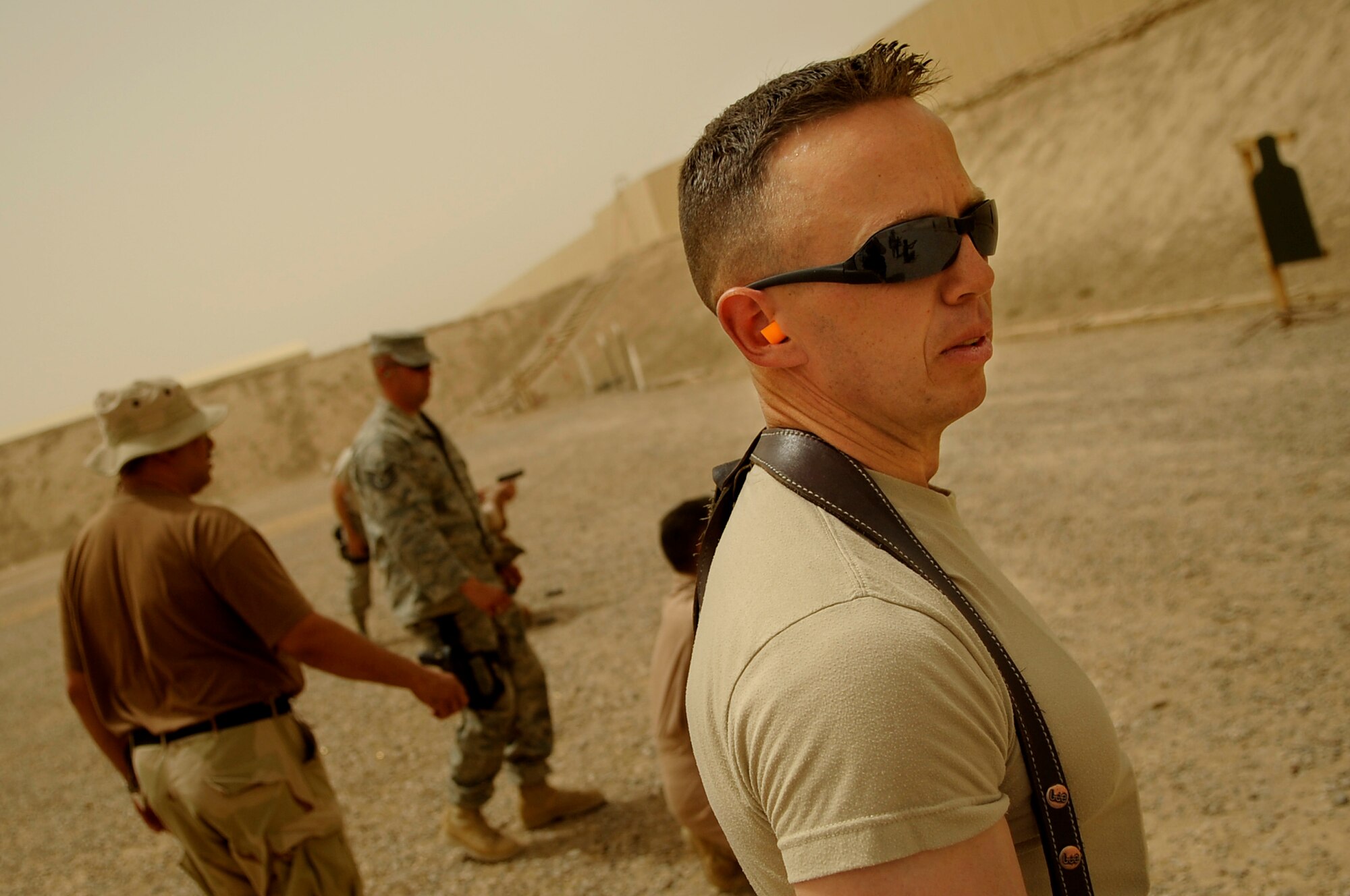 SATHER AIR BASE, Iraq -- Master Sgt. Charles Rivera ,Coalition Air Force Training Team at New Al Muthan Air Base, makes sure the firing line is clear during M-9 pistol training for a group of Iraqi jundees at a range near Sather Air Base June 18. (U.S. Air Force photo/Tech. Sgt. Jeffrey Allen)