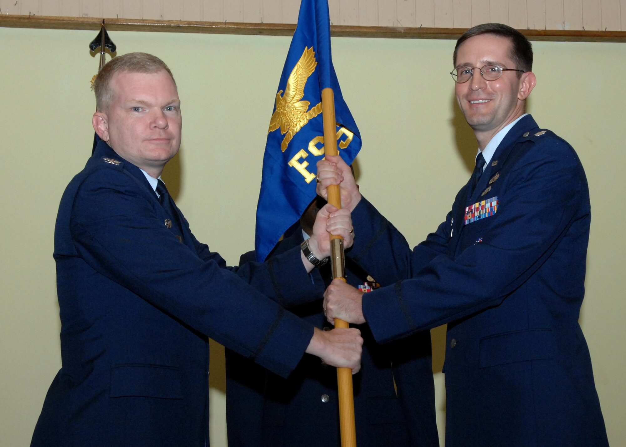 Col. Mark Talley 36th Mission Support Group commander presents  Lt. Col. Paul Nosek, former Mission Support Squadron commander with the 36th Force Support Squadron guidon, signifying the activation of the squadron and his assumption of command July 1 here. The 36th MSS and the 36th Services Squadron were deactivated and merged together creating a new squadron named the 36th FSS.(U.S. Air Force by Airman 1st Class Nichelle Griffiths) 