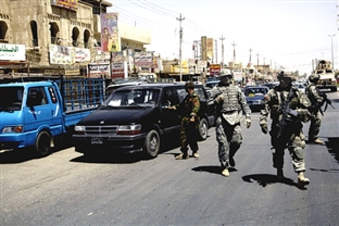 U.S. soldiers and Iraqi army soldiers cross the street during a patrol in the city of Amariyah, Iraq, June 28, 2008. The soldiers are assigned to the 4th Infantry Division's 4th Squadron, Commanche Troop, 10th Cavalry. 
