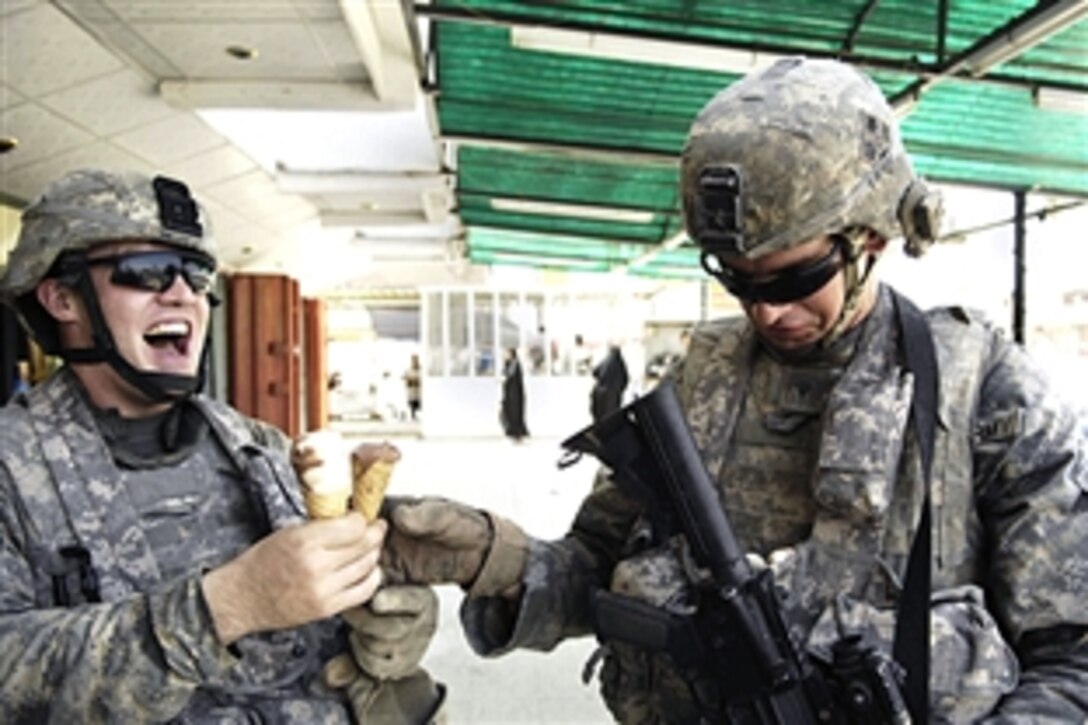 U.S. Army Spc. Jacob Miller, left, laughs as Spc. Michael Paniagua looks down at the ice cream that fell on his body armor during a patrol in Amariyah, Iraq, Jun 28, 2008. The soldiers are assigned to the 4th Infantry Division's Troop C, 4th Squadron, 10th Cavalry Regiment. 