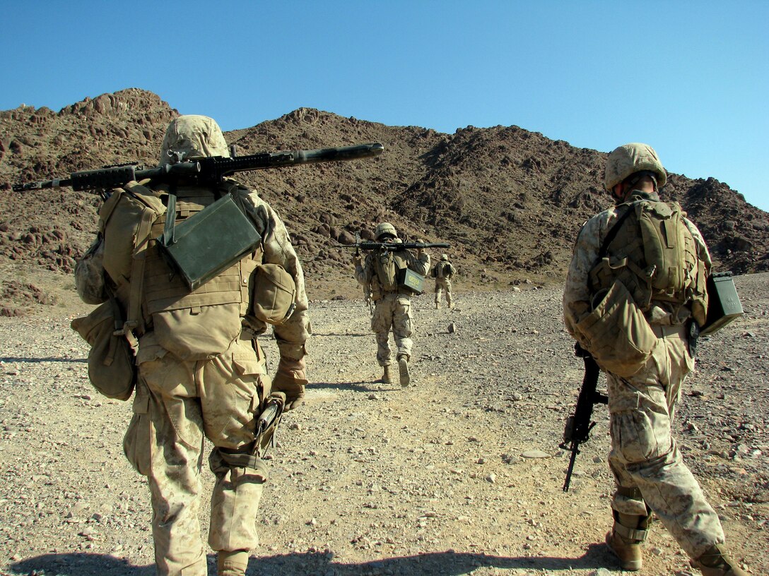 Loaded down with weapons and ammunition, an Echo Company machine gun squad trudges through the morning heat toward Machine Gun Hill at Range 400 here to provide direct support for a platoon assault during a live-fire exercise July 1, 2008.  The reserve company, headquartered in Harrisburg, Pa., is headed to Iraq in the fall with 2nd Battalion, 25th Marine Regiment.