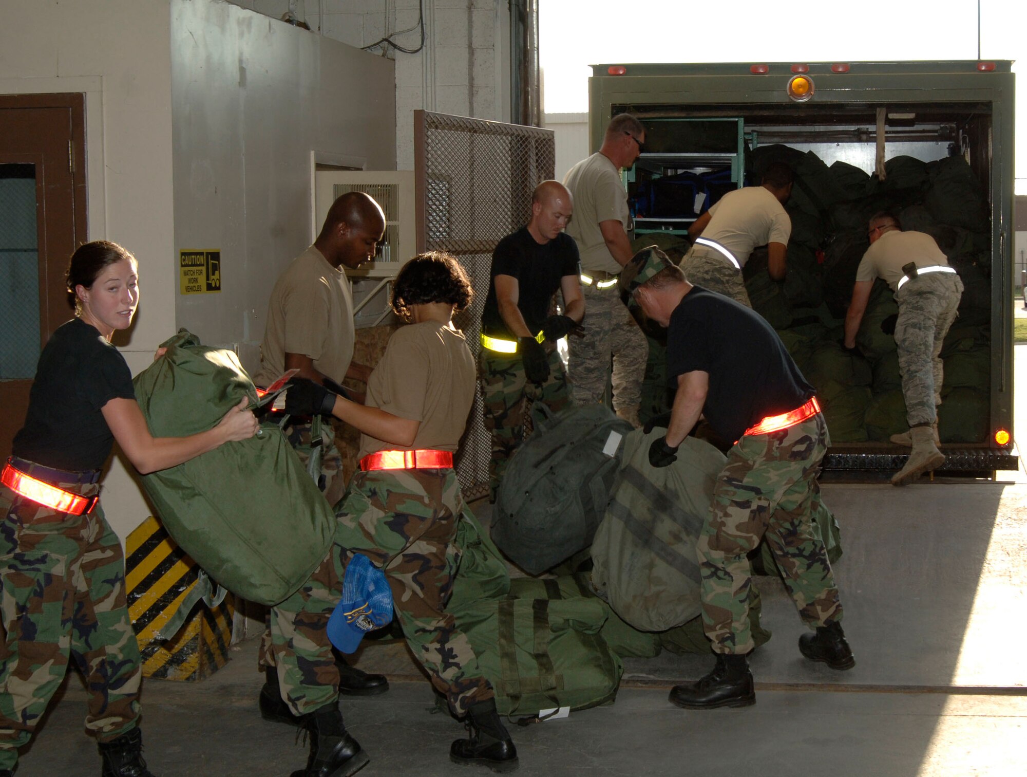 MCCONNELL AIR FORCE BASE, Kan. -- McConnell members empty out a panel van full of mobility bags at Bldg. 1090, June 28 after their fellow Airmen returned from an Operational Readiness Inspection. The 22nd Air Refueling Wing was graded by the Inspector General team for its ability to survive and operate during contingency operations on June 22 through 29 during an ORI.  (Photo by Senior Airman Roy Lynch III)
