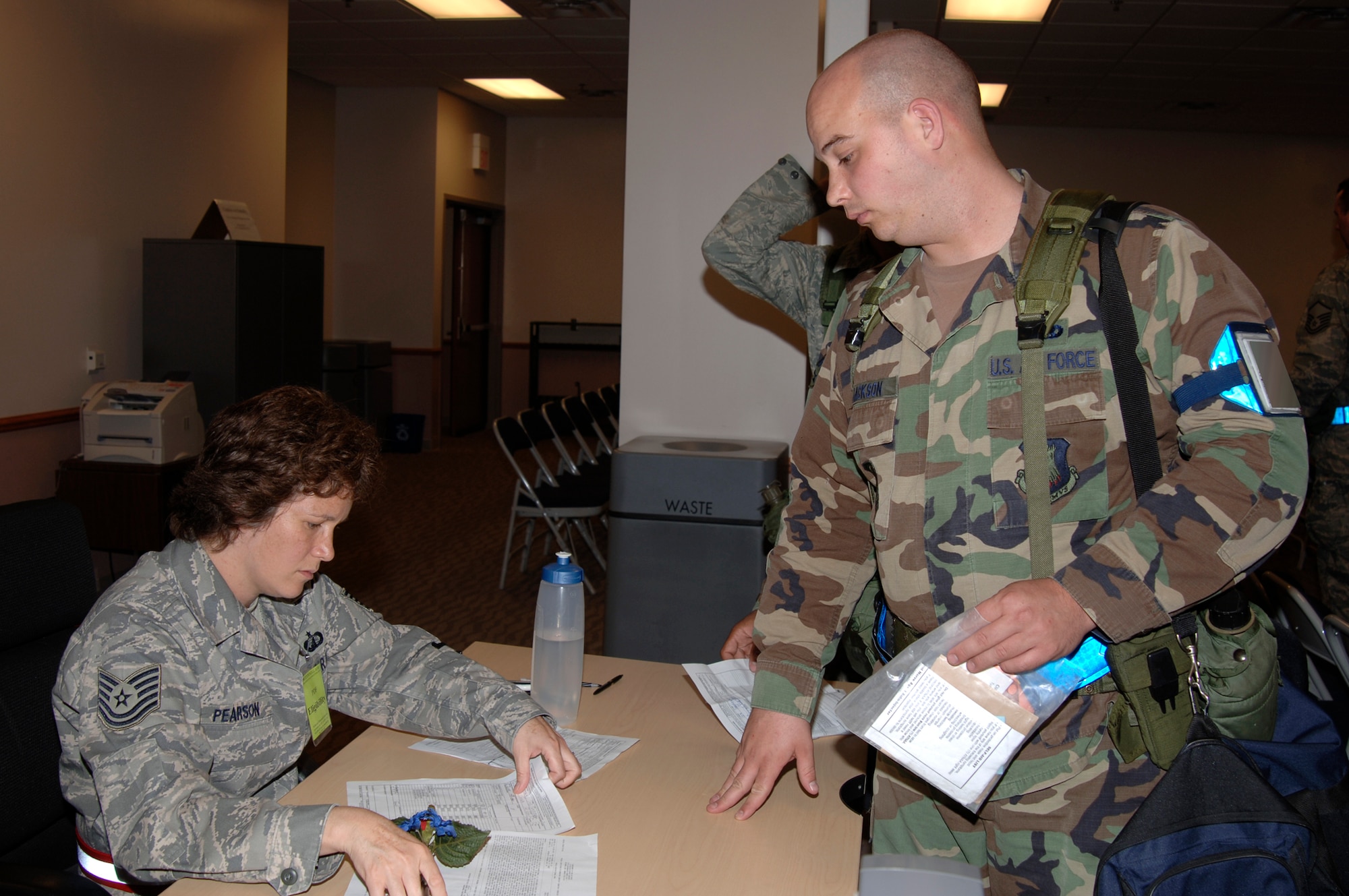 MCCONNELL AIR FORCE BASE, Kan. -- Technical Sgt. Kelly Pearson, 22nd Comptroller Squadron, takes a travel voucher from Airman 1st Class Joshua Jackson, 22nd Logistics Readiness Squadron, along with other Team McConnell personnel after their return from the Operational Readiness Inspection, June 28.  The deployed personnel had their basic allowance for subsistence temporarily halted and were paid for their travel. (Photo by Airman Justin Shelton)
