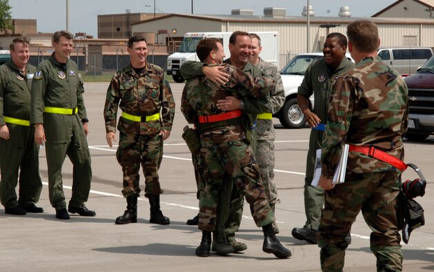 MCCONNELL AIR FORCE BASE, Kan. -- Team McConnell members welcome back one of their own from the recent Operational Readiness Inspection, June 28. McConnell members lined up outside of the plane to greet their comrades as they returned. (Photo by Airman Justin Shelton)