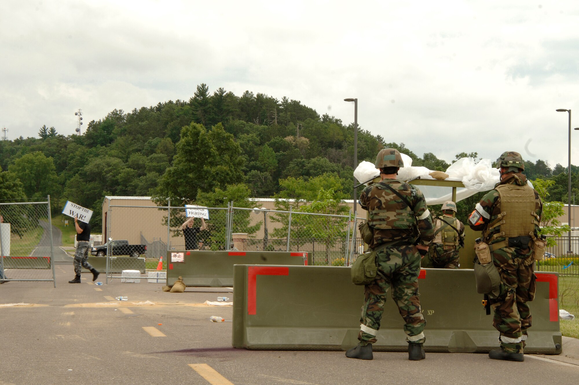 VOLK FIELD AIR NATIONAL GUARD BASE, Wis. -- 804th Security Forces Squadron stands guard against inspector generals posing as protesters at Volk field, Wis., June 27. The faux protesters confront security forces at the main gate with signs in an attempt to test their reaction to such a situation. (photo by Senior Airman Laura Suttles)