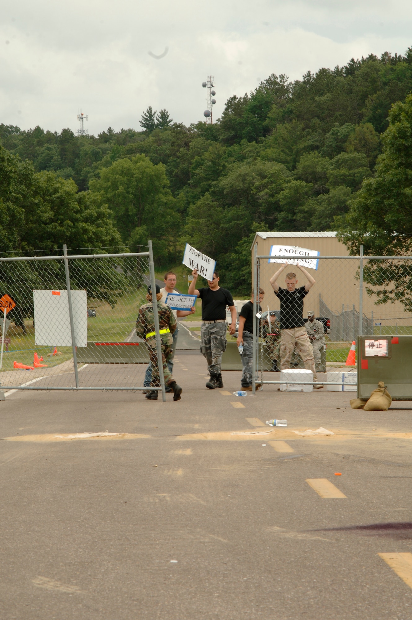 VOLK FIELD AIR NATIONAL GUARD BASE, Wis. -- Four inspector generals posing as local Japanese protesters, attempt to storm through a gate at Volk Field, Wis., June 27. The four “protesters” try to coax members of the 804th Security Forces Sqaudron during an exercise by yelling and throwing bottles towards them, over the fence. (photo by Senior Airman Laura Suttles)