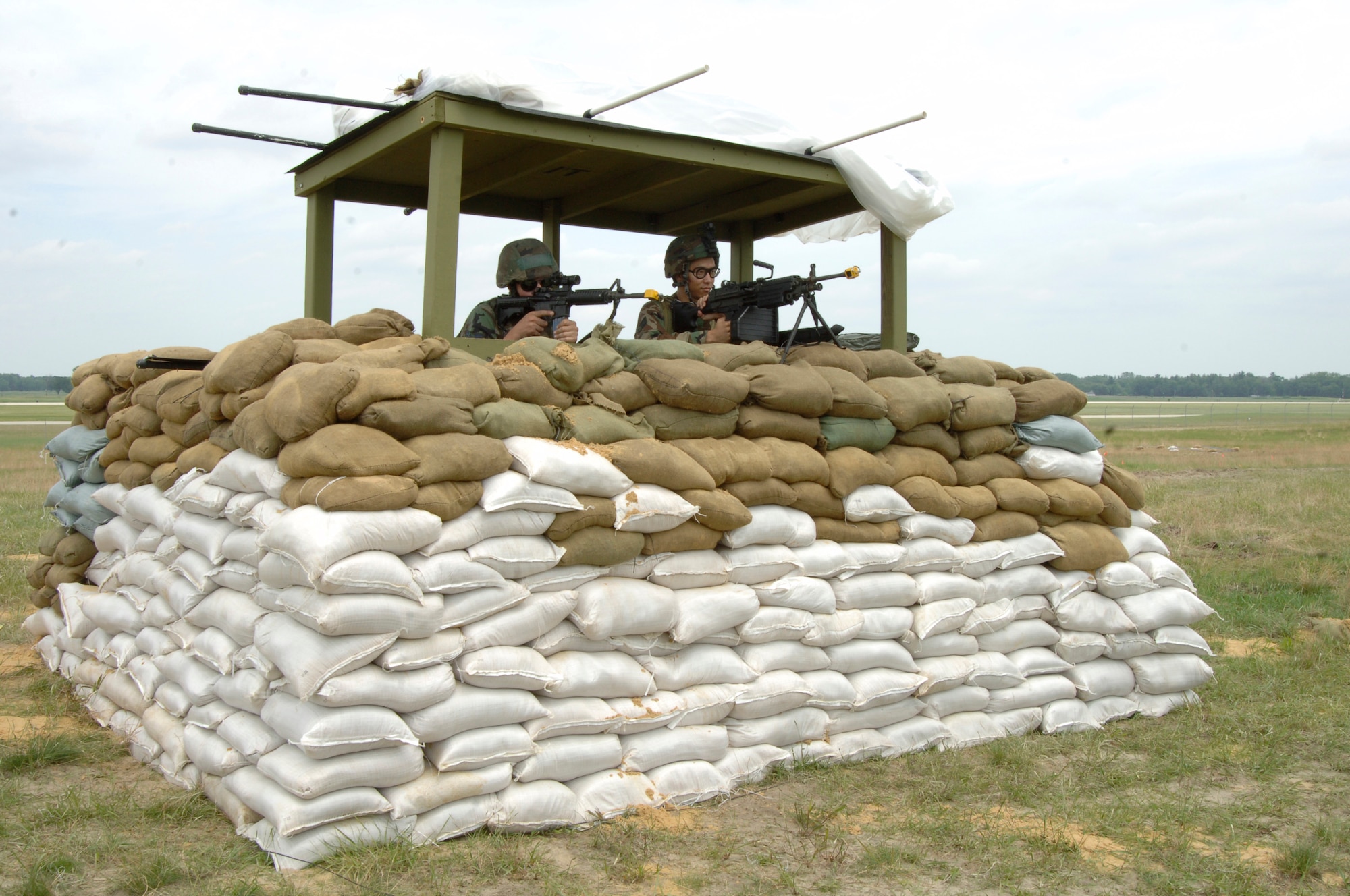 VOLK FIELD AIR NATIONAL GUARD BASE, Wis. -- Airman 1st Class Thomas Lucy and Senior Airman John Osborne, 804th Security Forces Squadron, keep watch from their defensive fighting position (DFP) at Volk Field, Wis., June 25. A DFP is generally a deep pit, so that only the head can be seen, to avoid fire. (photo by Senior Airman Laura Suttles) 
