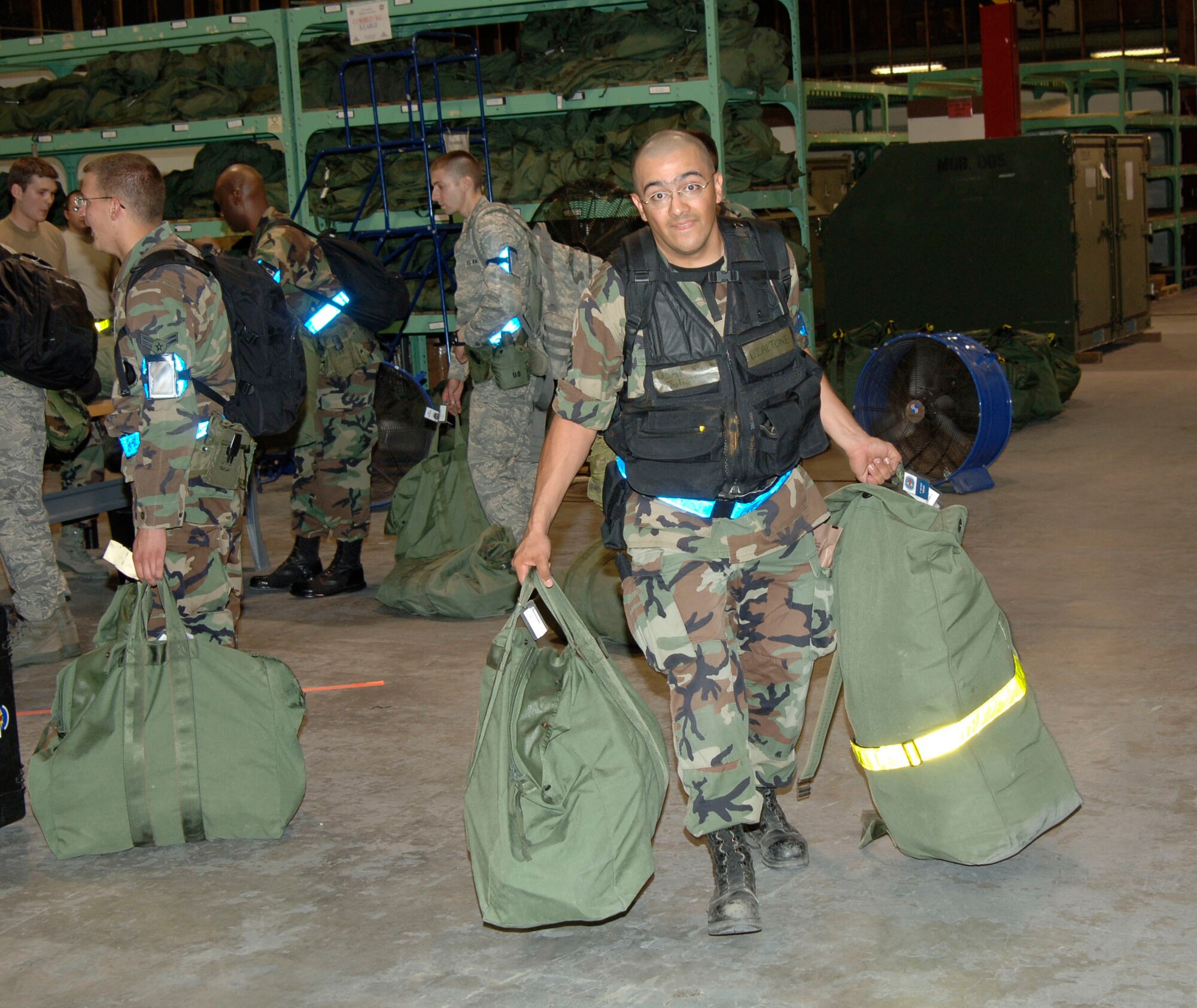 MCCONNELL AIR FORCE BASE, Kan. -- Staff Sgt. Julio Vega, 22nd Communications Squadron, carries mobility bags through a mobility line at Bldg. 1090, June 23, in preparation for an Operational Readiness Inspection. An Inspector General team evaluated members individually and in groups during the ORI, which ran from June 22 to June 29 at Volk Field, Wisconsin. (Photo by Senior Airman Roy Lynch III)