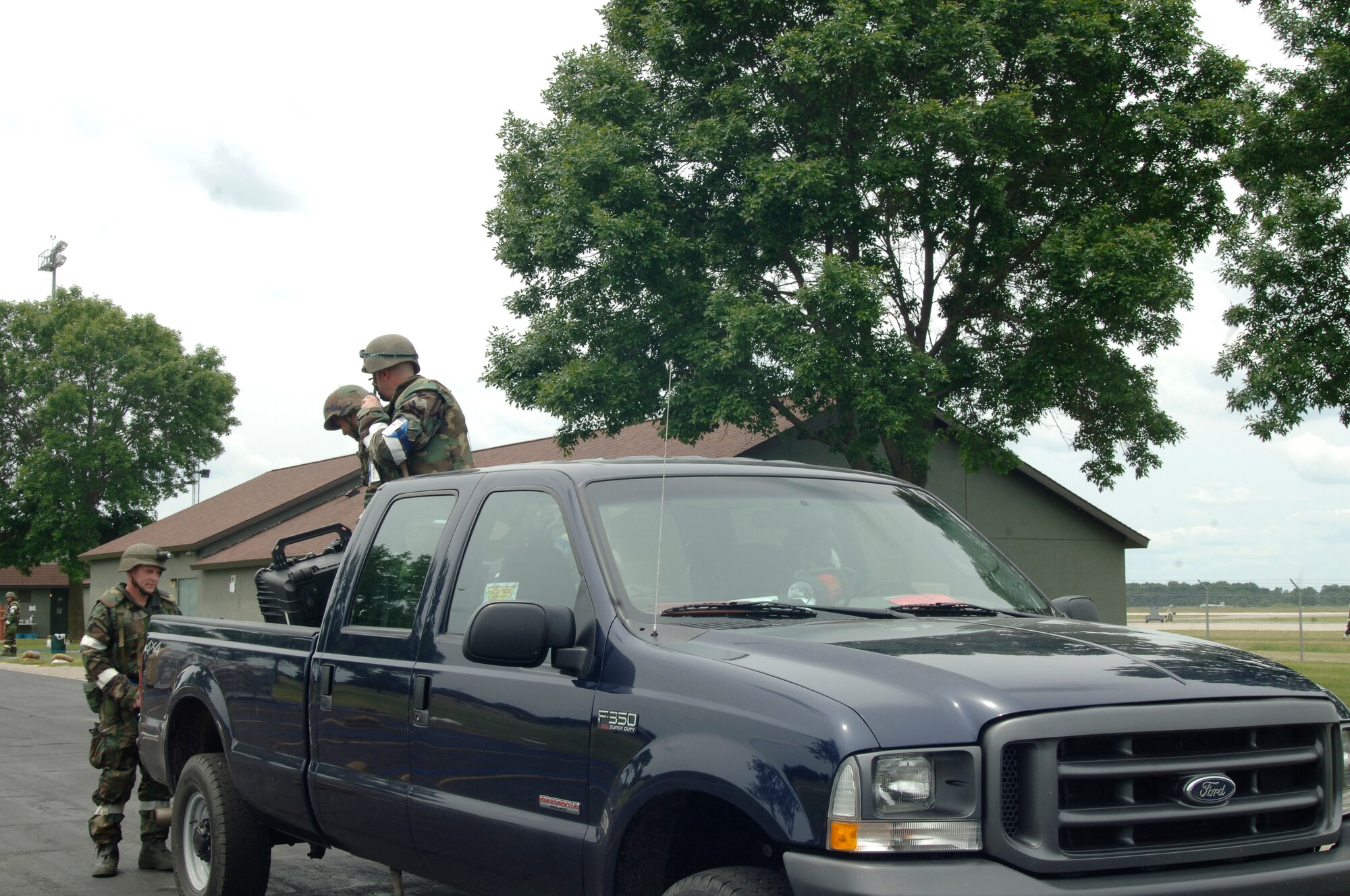 VOLK FIELD AIR NATIONAL GUARD BASE, Wis. -- Contaminated personnel load up into a truck bed to be transported to the decontamination hanger at Volk Field, Wis., June 26. Crews with their Mission Oriented Protective Posture gear rode inside trucks that carried chemical contaminated personnel in their truckbeds.(photo by Senior Airman Laura Suttles)