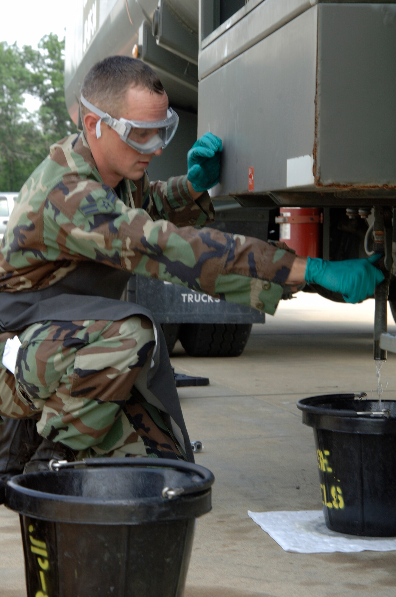 VOLK FIELD AIR NATIONAL GUARD BASE, Wis. -- Airman 1st Class Matt Cavazos, 804th Logistics Readiness Squadron, collects fuel at Volk Field, Wis., June 25. Airman Cavazos asessed a fuel mishap, which caused him to deplete old fuel from a fuel truck and dump it into a tank. (photo by Senior Airman Laura Suttles)