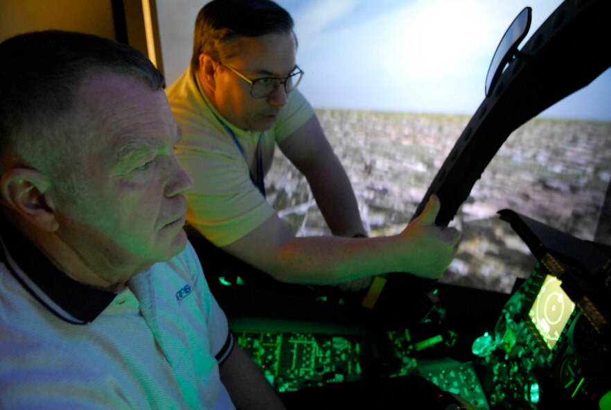 An A-10C full mission trainer operator at Moody AFB, GA, Steven Callich, right, highlights features of the digitally-upgraded ground attack aircraft to retired Maj. Gen. Francis Gideon, former A-10A test pilot. The general retied in 2000 as the Air Force chief of safety. (photo by Tech. Sgt. Parker Gyokeres)