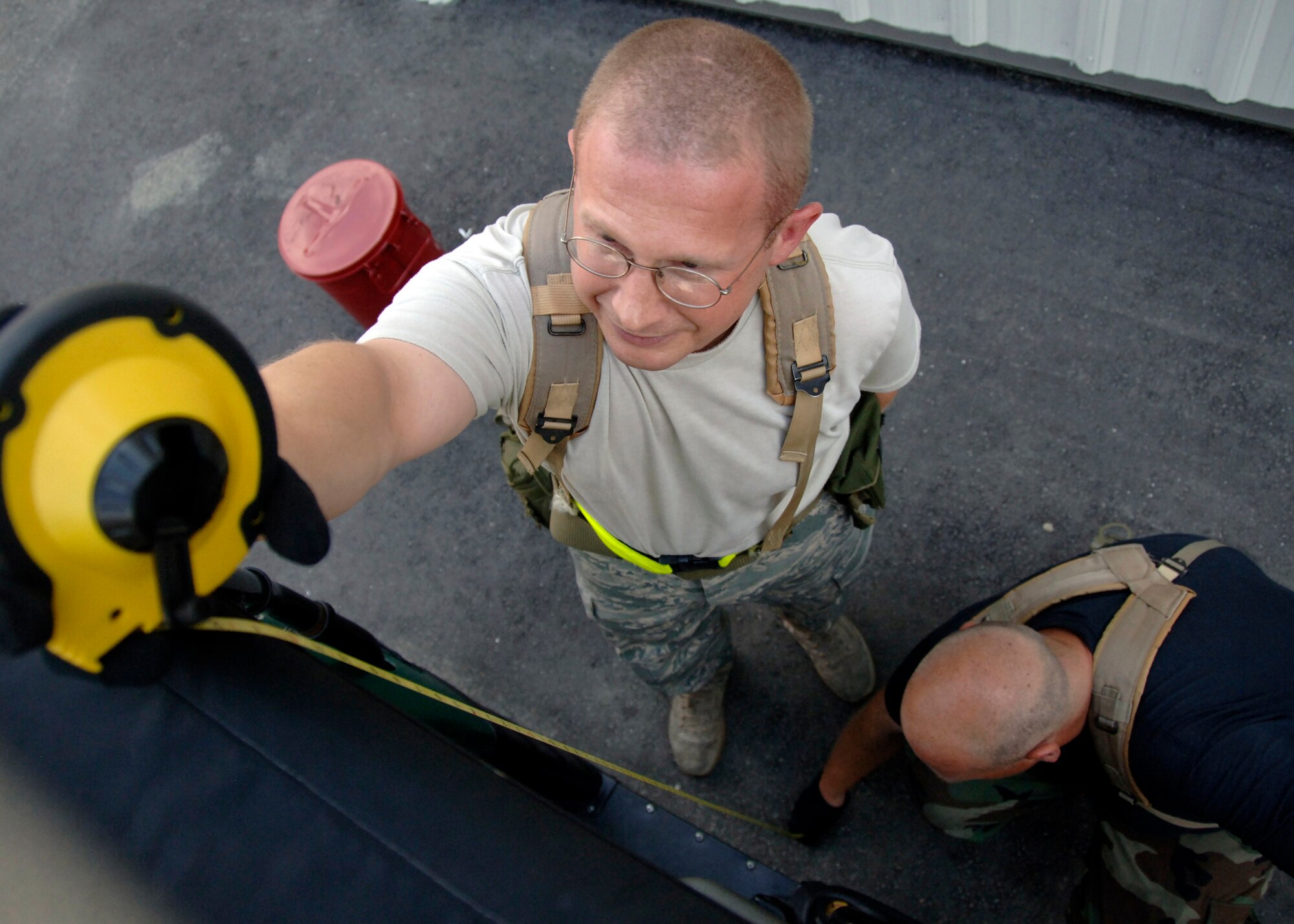 Tech. Sgt. Shannon Frank measures the height of the all-terrain vehicle as Senior Airman Chris Hickie secures the tape measure to the bottom before a cargo move in the 437th Aerial Port Squadron cargo yard July 2. Airmen across the base are participating in weekly exercises to prepare for the Headquarters Air Mobility Command operational readiness inspection in August. Sergeant Frank is a aircraft cargo processing supervisor and Airman Hickie is an aircraft cargo processing journeyman for the 437 APS. (U.S. Air Force photo/Airman 1st Class Timothy Taylor)
