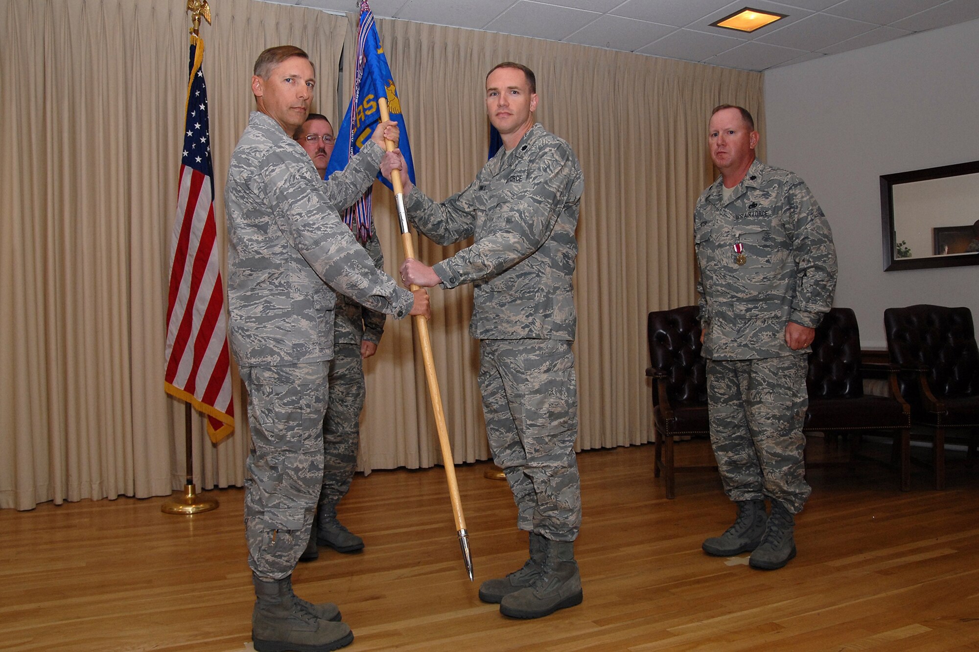 Col. Roderick Davis, 341st Mission Support Group commander, hands the 341st Logistics Readiness guidon to incoming commander Lt. Col. Ray Jones. Outgoing commander Lt. Col. James Baxter and 341st LRS first sergeant Master Sgt. James Jackson, look on. (U.S. Air Force photo/John Turner)