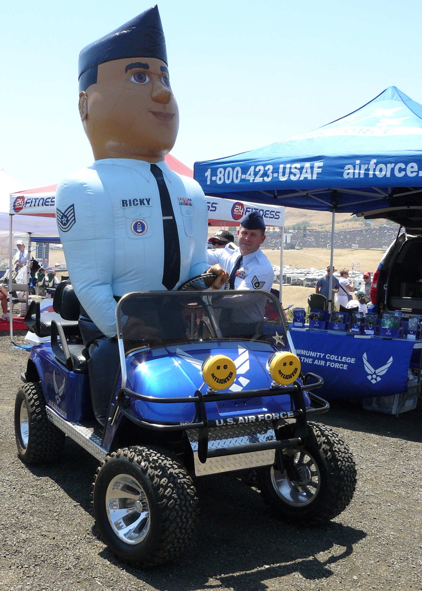 “Ricky the Recruiter” joins in on the fun by driving the decked-out “Predator” customized golf cart that debuted at the Toyota/Save Mart 350 NASCAR race held at the Infineon Raceway NASCAR race in Sonoma, Calif., June 22. The costumed recruiter assistant is helped into the cart by Staff Sgt. Michael Friend. “I asked my marketing team to think big and outside of the box and they delivered,” said Lt. Col. Ruben Rios, 364th Recruiting Squadron commander. (U.S. Air Force photo/Staff Sgt. Justin Gress)