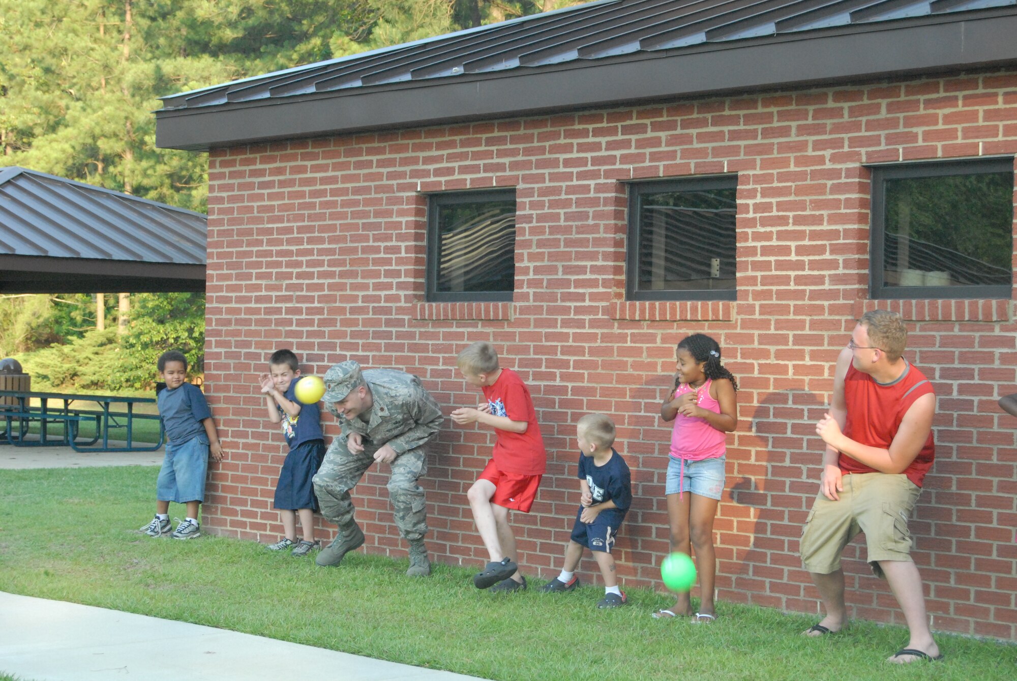 Maj. Jonathan Wright, 43rd Contracting Squadron, dodges a ball along with children at the dinner for families of deployed members event June 24. Families participated in dodgeball, “Simon Says” and water balloon toss. (U.S. Air Force Photo by Staff Sgt. Jon LaDue)