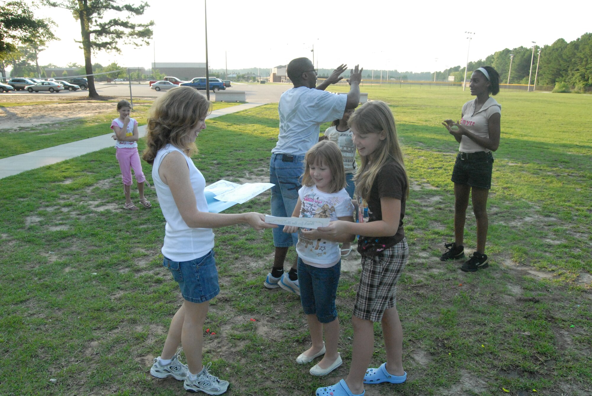 Bonnie McDonald hands out certificates to all the particpants of the water-balloon toss competition at the deployed spouses dinner at Woodland Park June 24. (U.S. Air Force Photo by Staff Sgt. Jon LaDue)