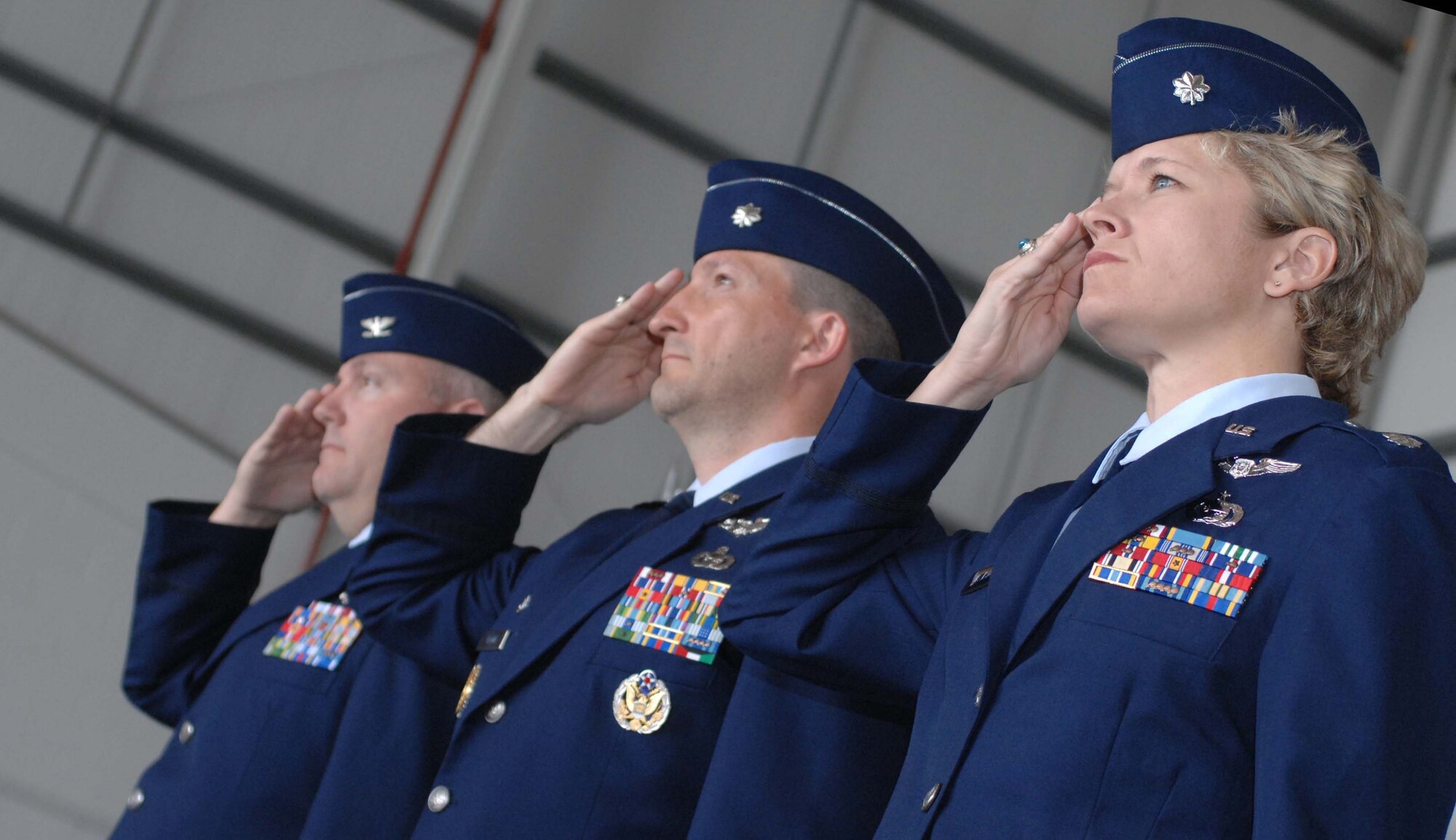 Col. Jeffrey Herd (left), 55th Operations Group commander from Offutt Air Force Base, Neb., salutes the flag alongside Lt. Col. Patrick Flood and Lt. Col. Ginger Wallace July 2 during the 488th Intelligence Squadron change of command ceremony.  Lt. Col. Wallace, who joins Team Mildenhall from Air Force Personnel Center at Randolph Air Force Base, Texas, is assuming command from Lt. Col. Flood.  (U.S. Air Force photo by Amn Brad Smith)