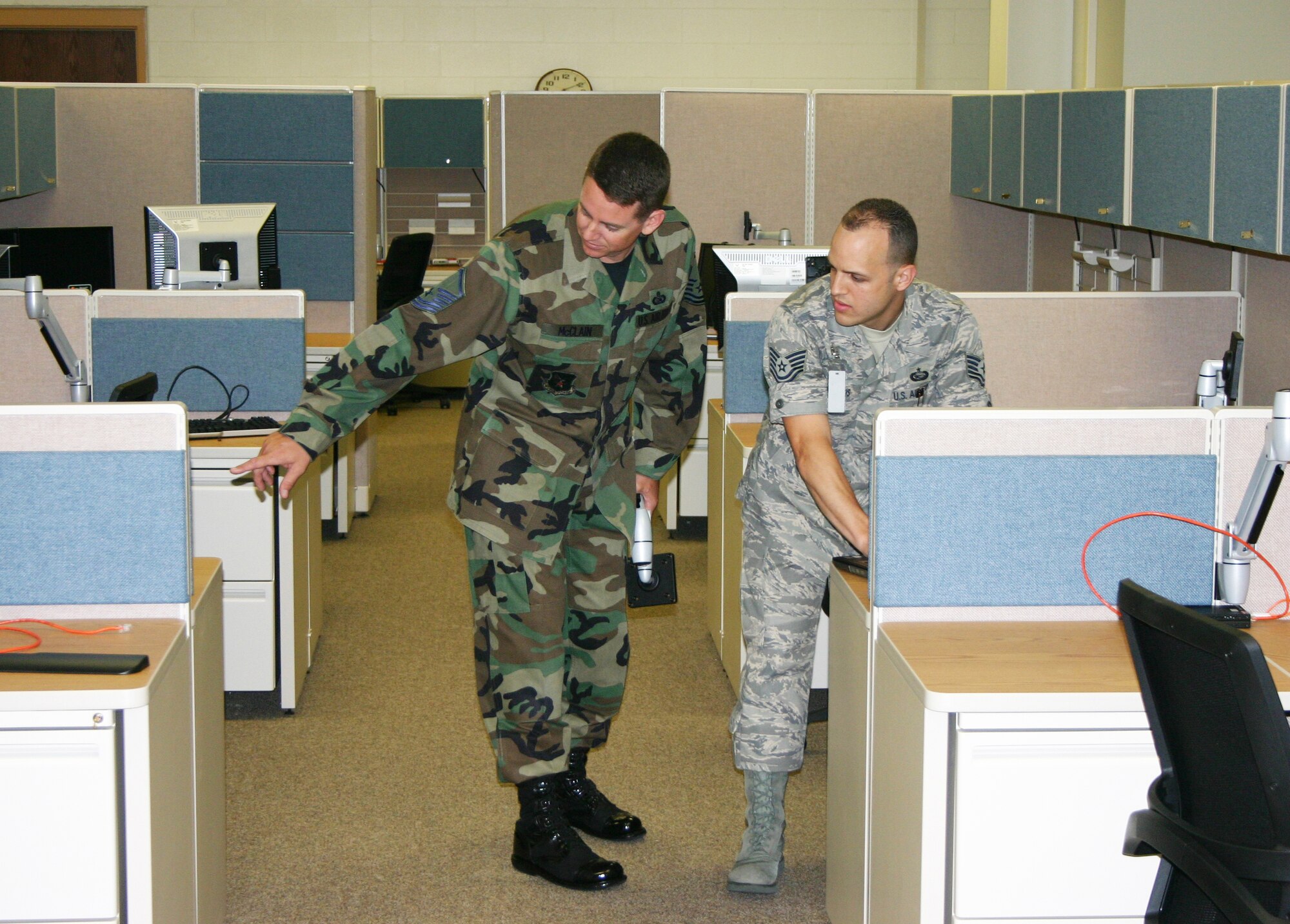 Master Sgt. Christopher McClain (left) and Tech. Sgt. Hector Matos, both relocation team members for AEF Operations at the Air Force Personnel Center here, inspect new work stations at the center's revamped E-Wing, which will soon hold more than 200 people. (U.S. Air Force photo/Richard Salomon)