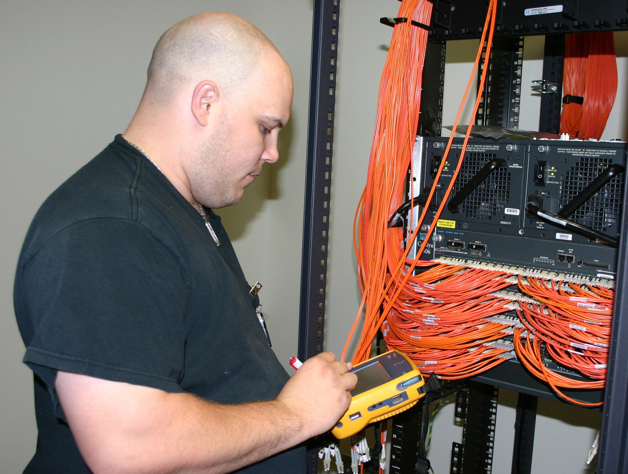 Gregory Campbell, a network data communication analyst at the Air Force Personnel Center here, verifies cable ports for the new operation center's network switch.  The switch's components feed down from a secure server and will give AEF workers secure lines once the operation center is fully operational.  Since November 2007, more than 12,000 feet of combined fiber optic and copper cables have been placed in the new center. (U.S. Air Force photo/Richard Salomon)