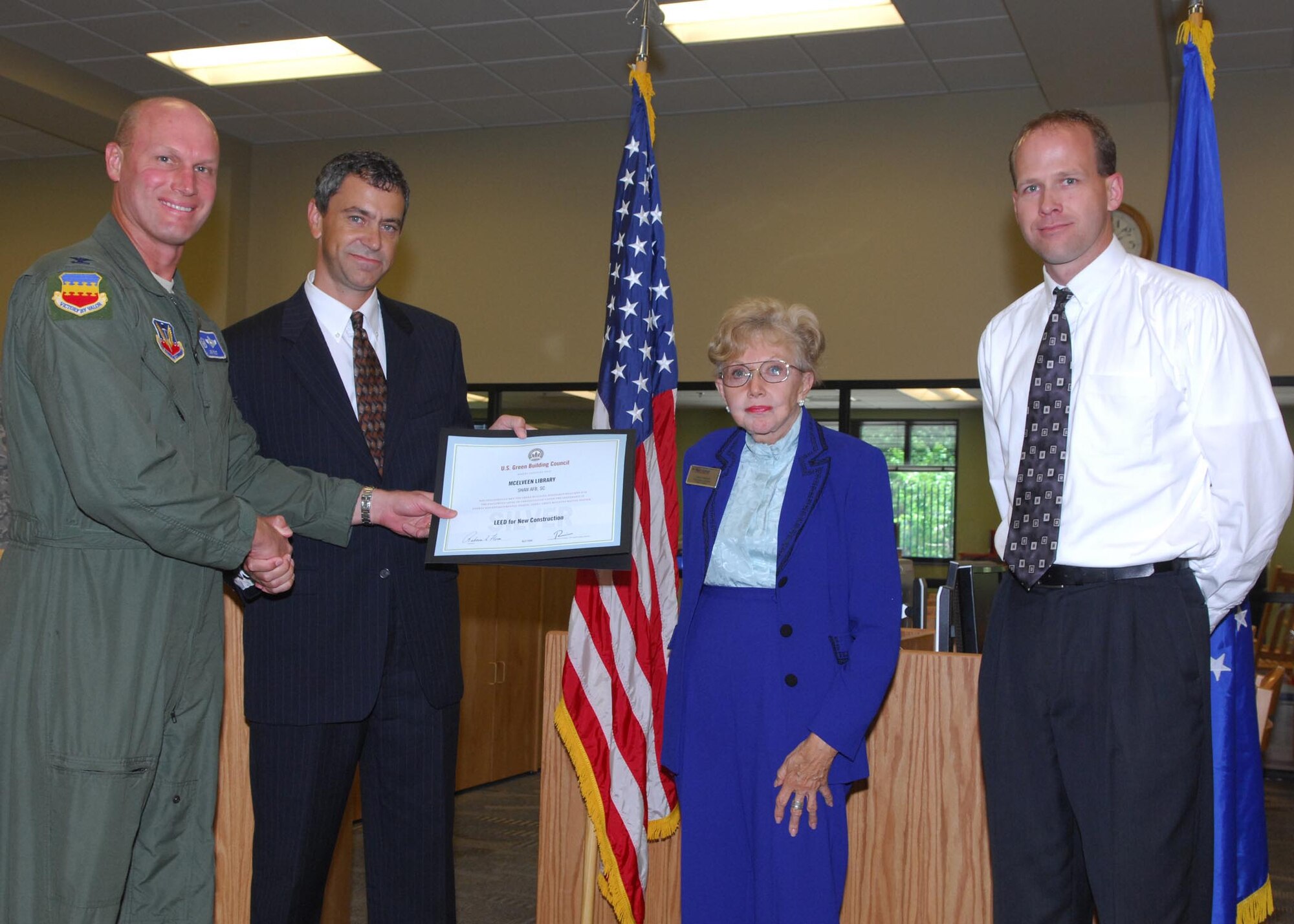 SHAW AIR FORCE BASE, S.C. -- Col. James Post, 20th Fighter Wing commander, Deon Grinell, McEleveen Library director and Chris Aamold, 20th Civil Engineer Squadron deputy commander, accept the Leadership in Energy and Enviromental Design Silver Certificaton from Michael Mantai, U.S. Green Building Council South Carolina chapter president July 1. The Shaw's library was awarded the LEED Silver Certification for its environmental and financial benefits. (U.S. Air Force photo/Airman 1st Class Matthew Davis)