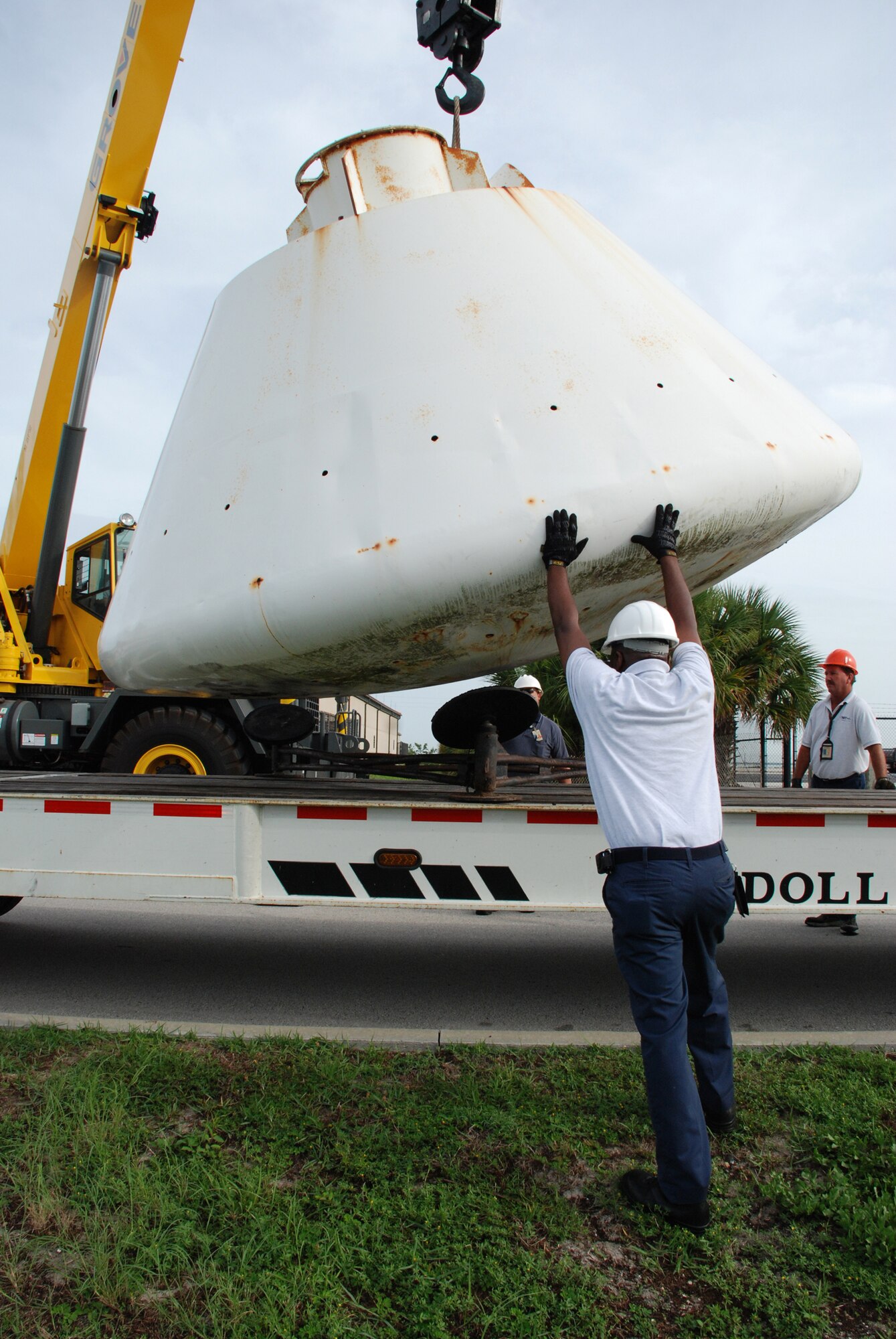 Workers at Patrick Air Force Base, Fla., help guide the 9,000-pound Apollo Boilerplate #1206 onto a flatbed truck for transportation to a local refurbishment facility. On loan here to the Air Force Reserve's 920th Rescue Wing from the Smithsonian Institute's Air and Space Museum, the capsule was once used by Air Force rescue units to train for astronaut recovery during the Apollo and Skylab space programs. (U.S. Air Force photo/Capt. Cathleen Snow)