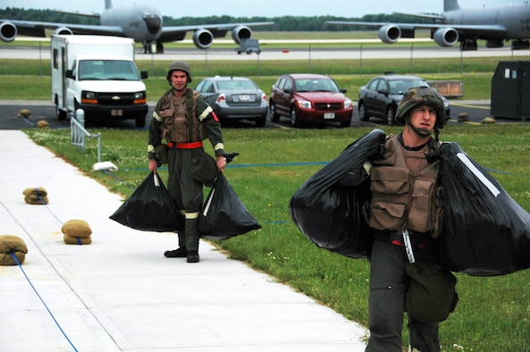 Staff Sgt. James Guldjord (right) and Capt. Scott Meyer carry equipment protected from simulated contamination while waiting for a third crew member during an Operational Readiness Inspection at Volk Field Air National Guard Base, Wis., on June 27.  Both are members of the 18th Air Refueling Squadron, the flying squadron of the 931st Air Refueling Group.  The results of the inspection are scheduled to be announced at an outbrief on July 3 at McConnell AFB. (U.S. Air Force photo/Tech. Sgt. Jason Schaap)