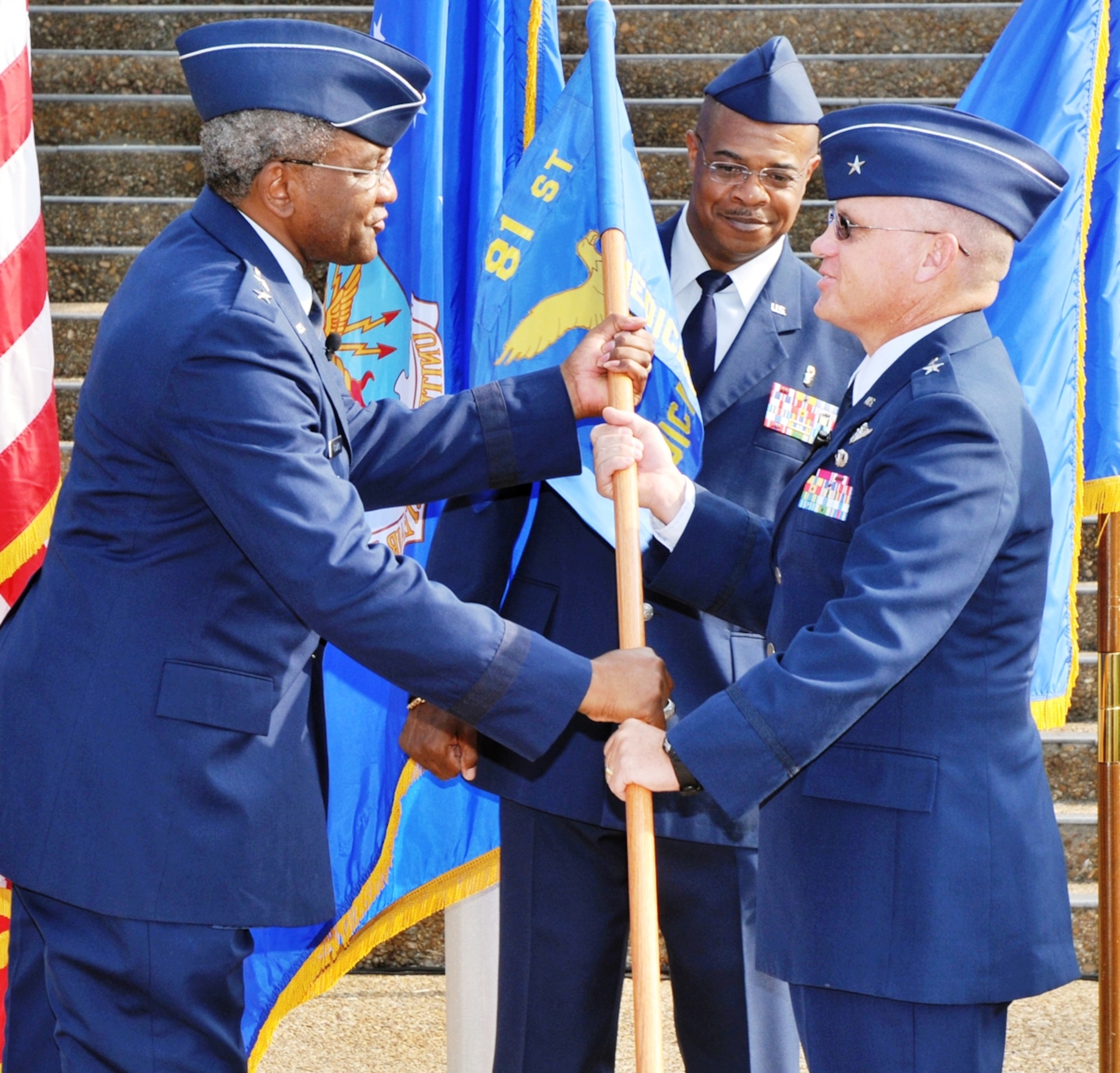 Brig. Gen. (Dr.) Dan Wyman, right, 81st Medical Group commander, accepts the medical group guidon from Maj. Gen. Alfred Flowers, 2nd Air Force commander, signifying the acceptance of command during the June 18 change of command ceremony.  Chief Master Sgt. Leon Hall, 81st MDG superintendent, assisted.  General Wyman succeeded Brig. Gen. (Dr.) Doug Robb.  The new medical group leader came to Keesler from Hickam AFB, Hawaii, where he served as Pacific Air Forces command surgeon and the 13th Air Force surgeon starting in June 2006.  General Robb is the new command surgeon for Air Mobility Command at Scott AFB, Ill.  (U.S. Air Force photo by Adam Bond)