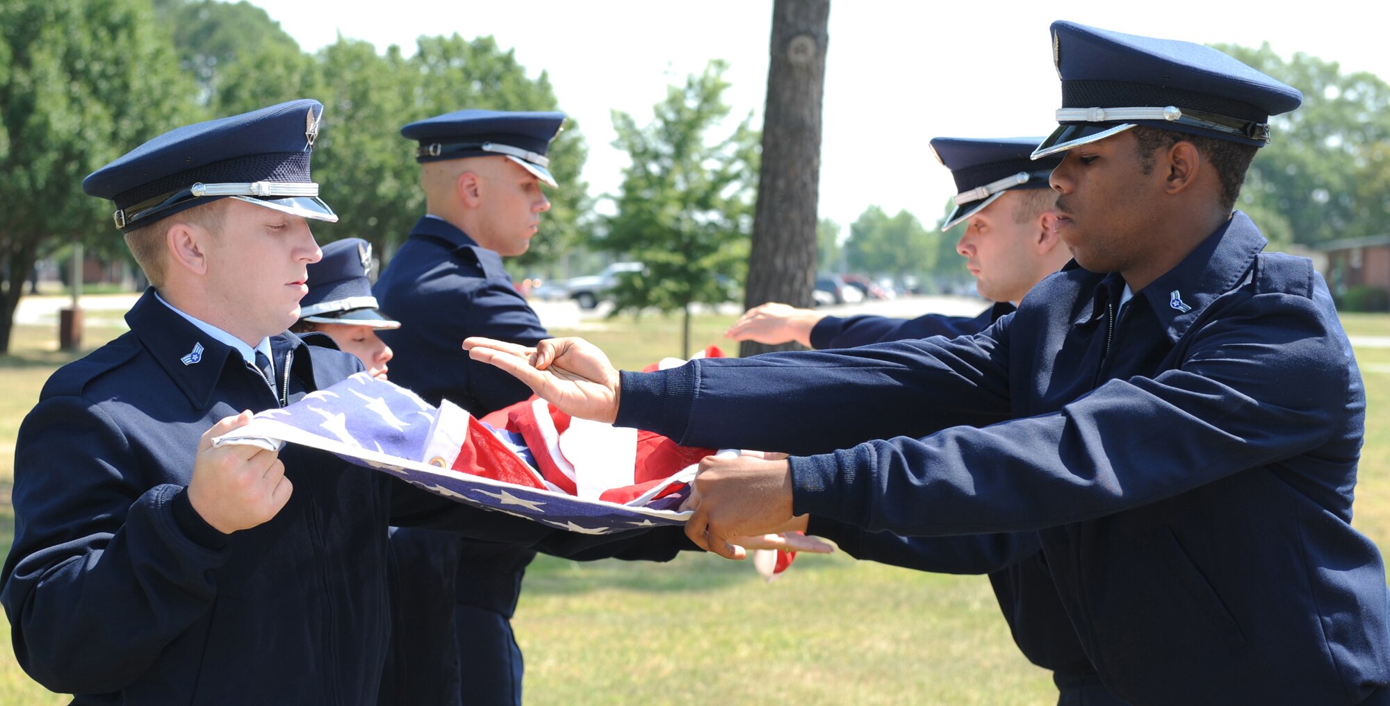 SEYMOUR JOHNSON AIR FORCE BASE, N.C.- Base honor guard members, Staff Sgt. Richard Allen, Senior Airman Tiffany Legree, Airman 1st Class Jason Hochsprung,  Senior Airman Houston Kirkeide, Airman 1st Class Joseph Perry, Airman 1st Class Marcus Smith hold the flag high with pride while folding on June 24. The folding of the flag renders respect to the servicemember that passed. (U.S. Air Force photo by Airman 1st Class Whitney Stanfield)