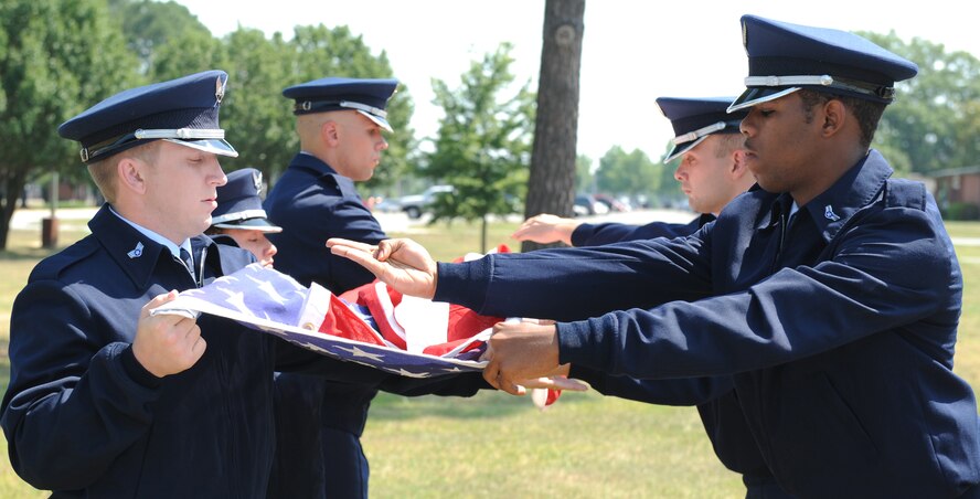 SEYMOUR JOHNSON AIR FORCE BASE, N.C.- Base honor guard members, Staff Sgt. Richard Allen, Senior Airman Tiffany Legree, Airman 1st Class Jason Hochsprung, Senior Airman Houston Kirkeide, Airman 1st Class Joseph Perry, Airman 1st Class Marcus Smith hold the flag high with pride while folding June 24 here. The folding of the flag renders respect to the servicemember that passed. (U.S. Air Force photo by Airman 1st Class Whitney Stanfield) 