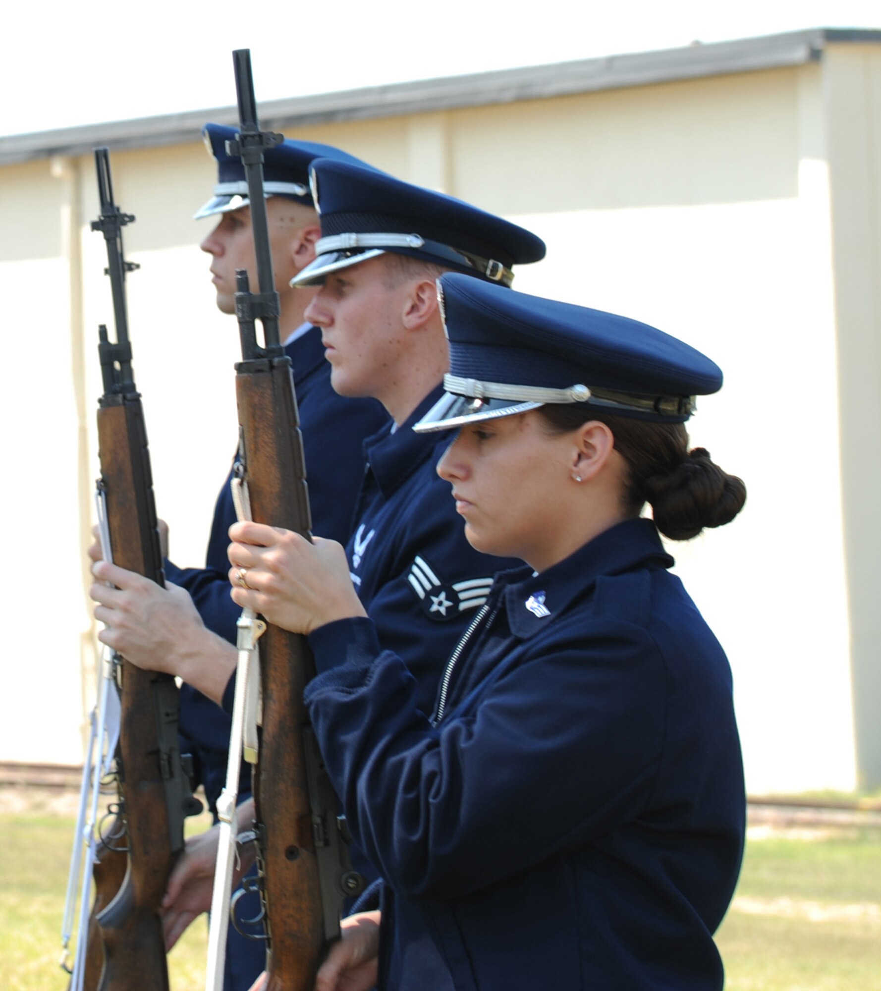 SEYMOUR JOHNSON AIR FORCE BASE, N.C.- Airman 1st Class Jason Hochsprung, Senior Airman Tiffany Legree, and Senior Airman Hoston Kirkeide, members of the firing party, stand at attention to render respect during "Taps" on June 24. Proper military bearing is a vital part of the base honor guard mission. (U.S. Air Force photo by Airman 1st Class Whitney Stanfield)