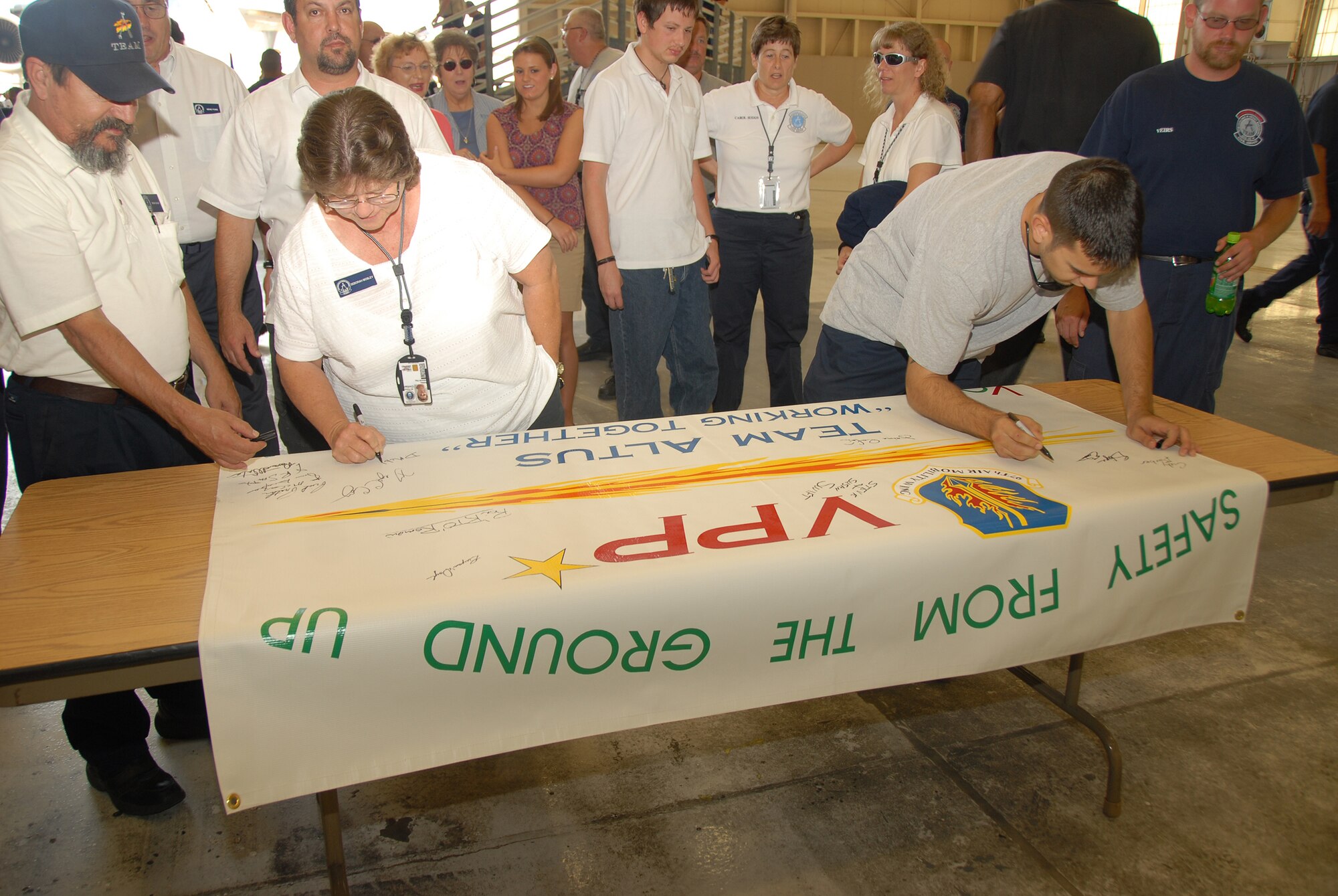 Altus Air Force Base 97th Maintenance Directorate employees add their names as endorsement to the new voluntary protection program agreement signed June 30 between Altus AFB and Ardmore Valero Refining which will provide mentorship to the "A-Team" as the civilian maintenance work force strives to reduce lost time accidents and illnesses.  (U.S. Air Force/A1C Jennifer Flores)